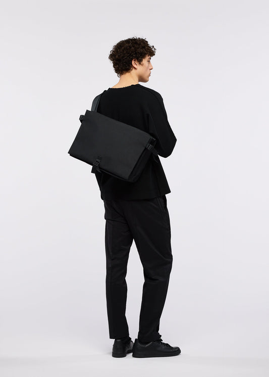 A model wears the GOOD GOODS ISSEY MIYAKE JABARA bag.