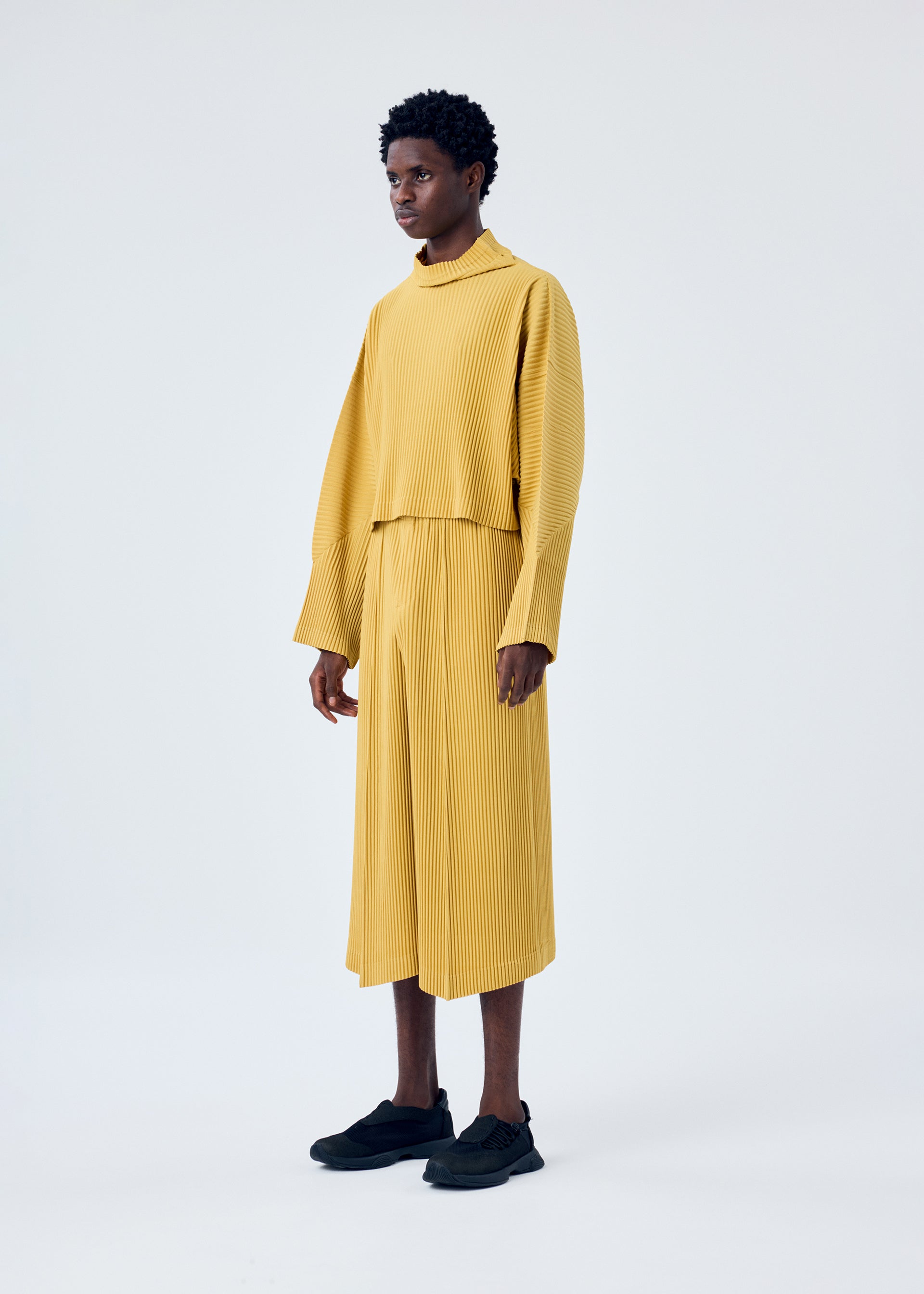 A model wears the HOMME PLISSÉ ISSEY MIYAKE MC JUNE top.