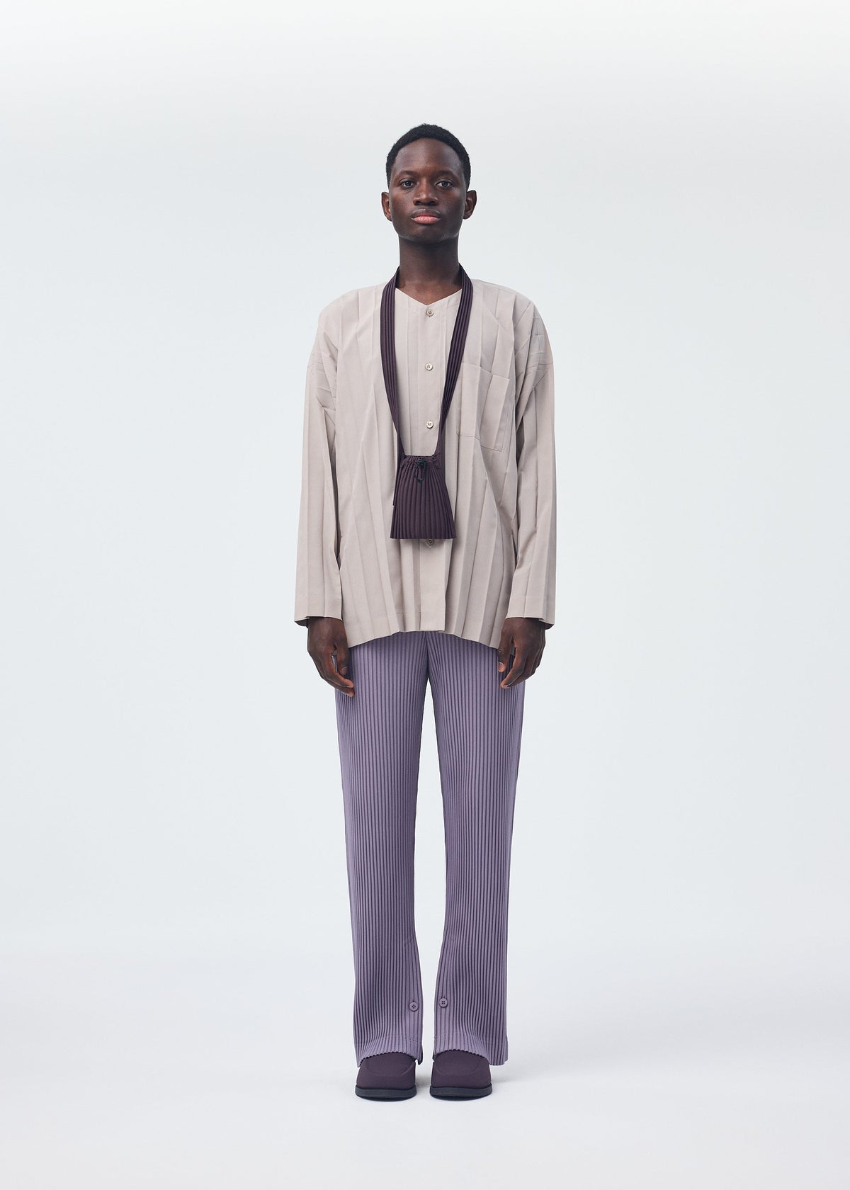 A model wears the HOMME PLISSÉ ISSEY MIYAKE POCKET bag.