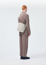 A model wears the Homme Plisse Issey Miyake UTILITY bag.