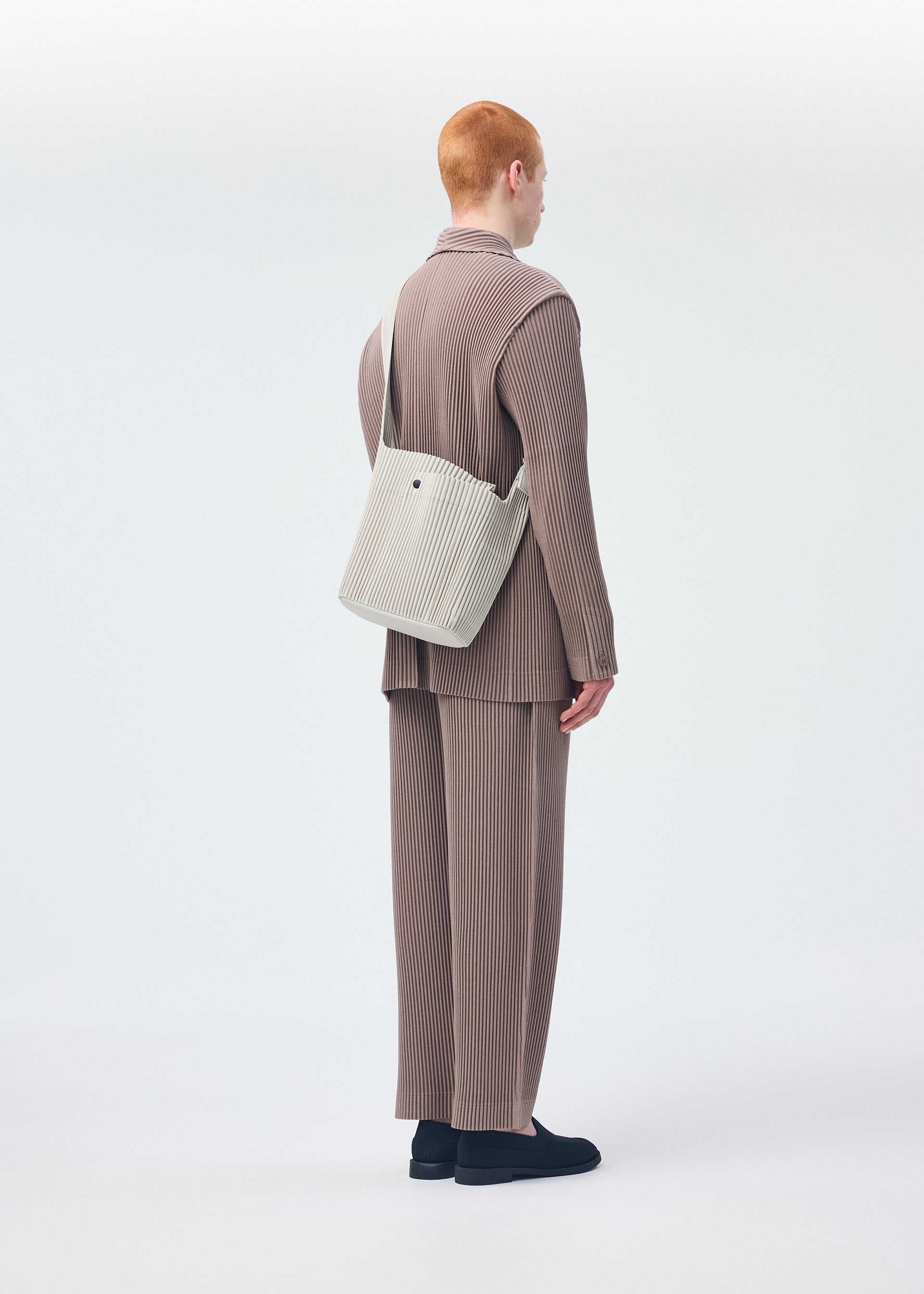 A model wears the Homme Plisse Issey Miyake UTILITY bag.