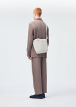 A model wears the Homme Plisse Issey Miyake UTILITY bag.