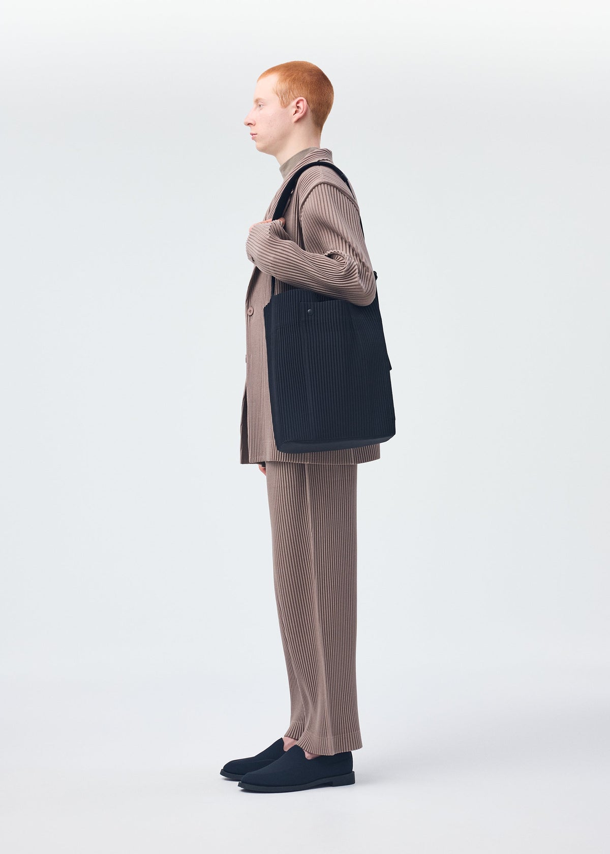 A model wears the Homme Plisse Issey Miyake UTILITY bag.