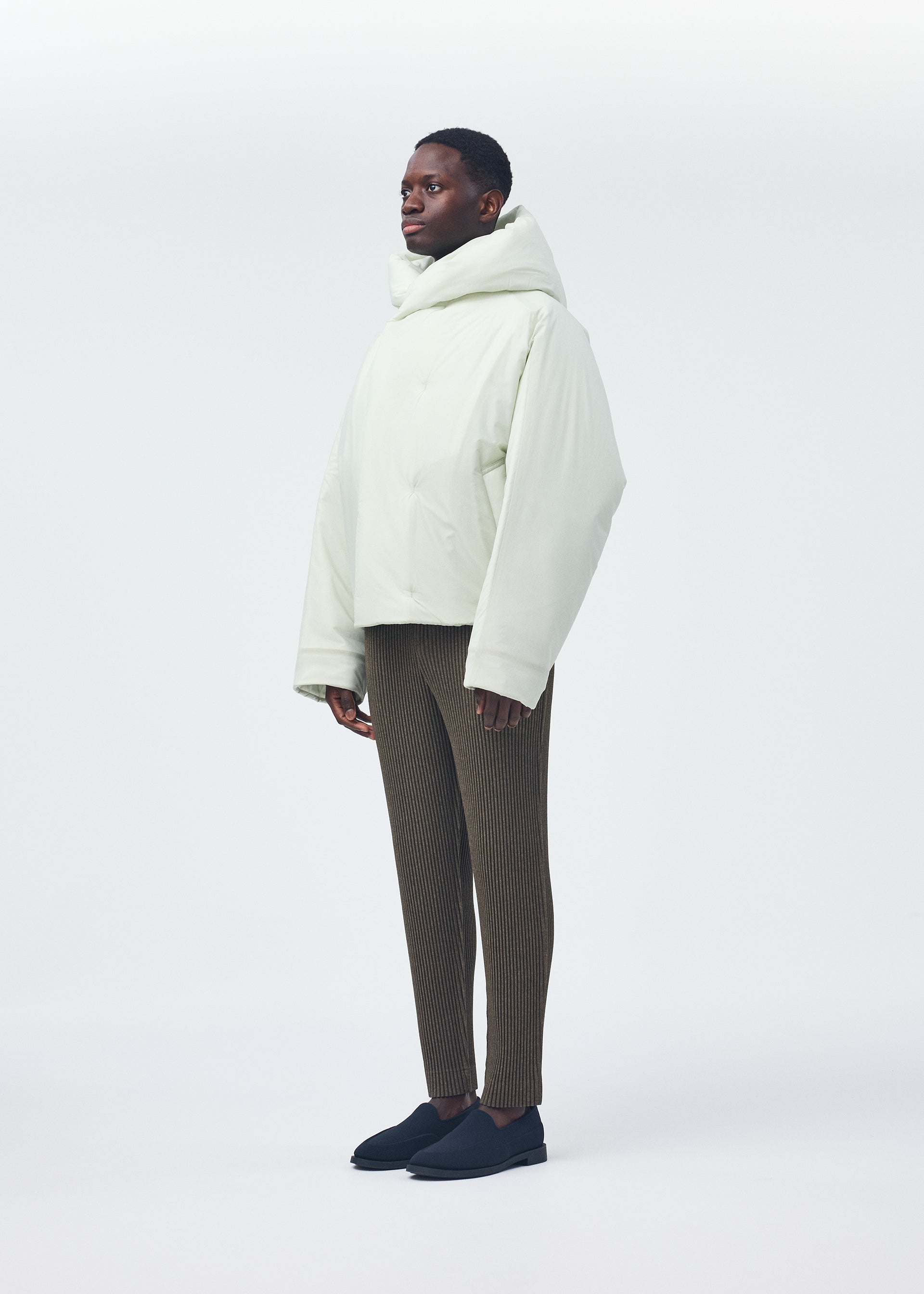 A model wears the Homme Plisse Issey Miyake DUVET COAT blouson.