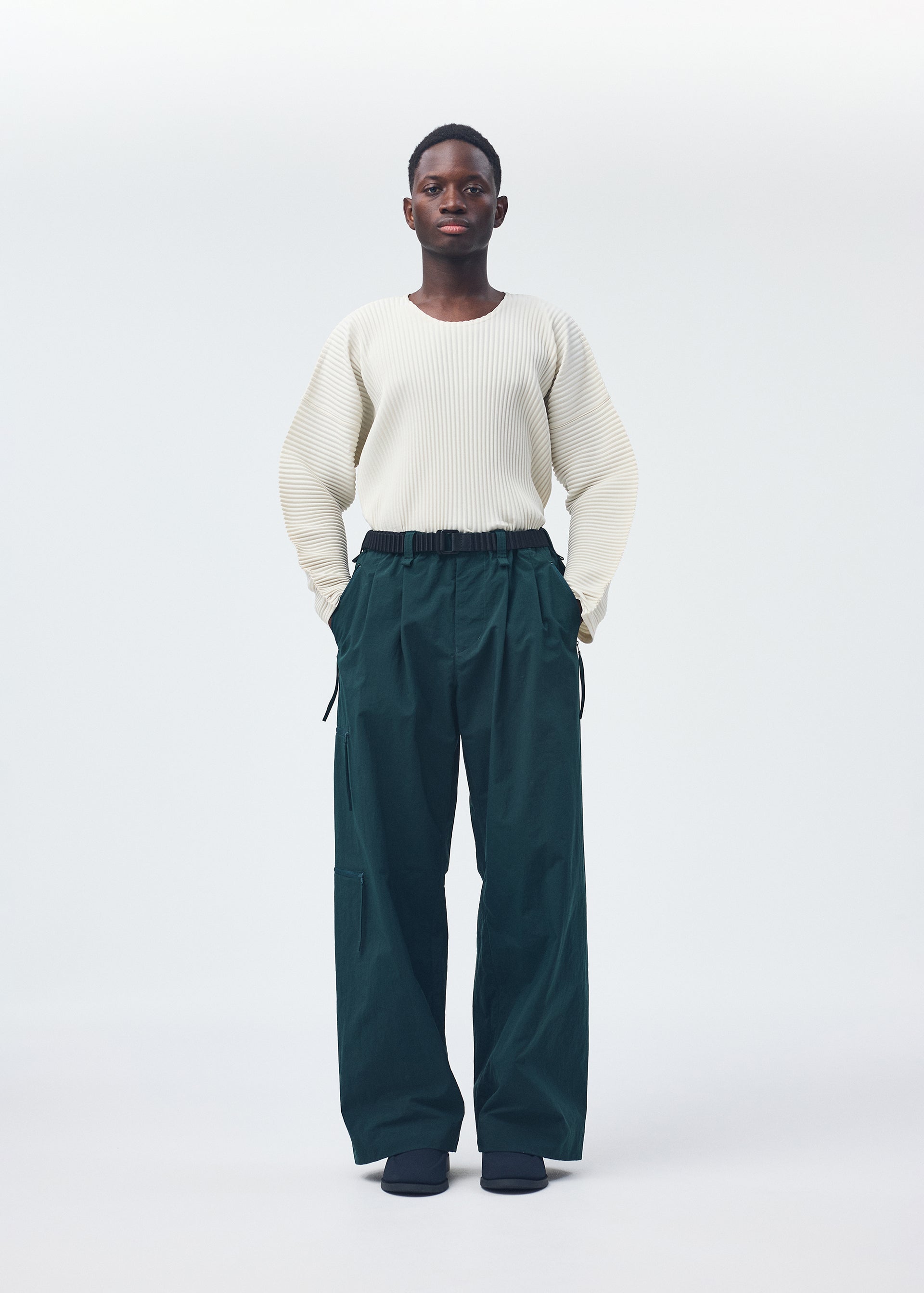 A model wears the Homme Plisse Issey Miyake QUARRY Trousers trousers.