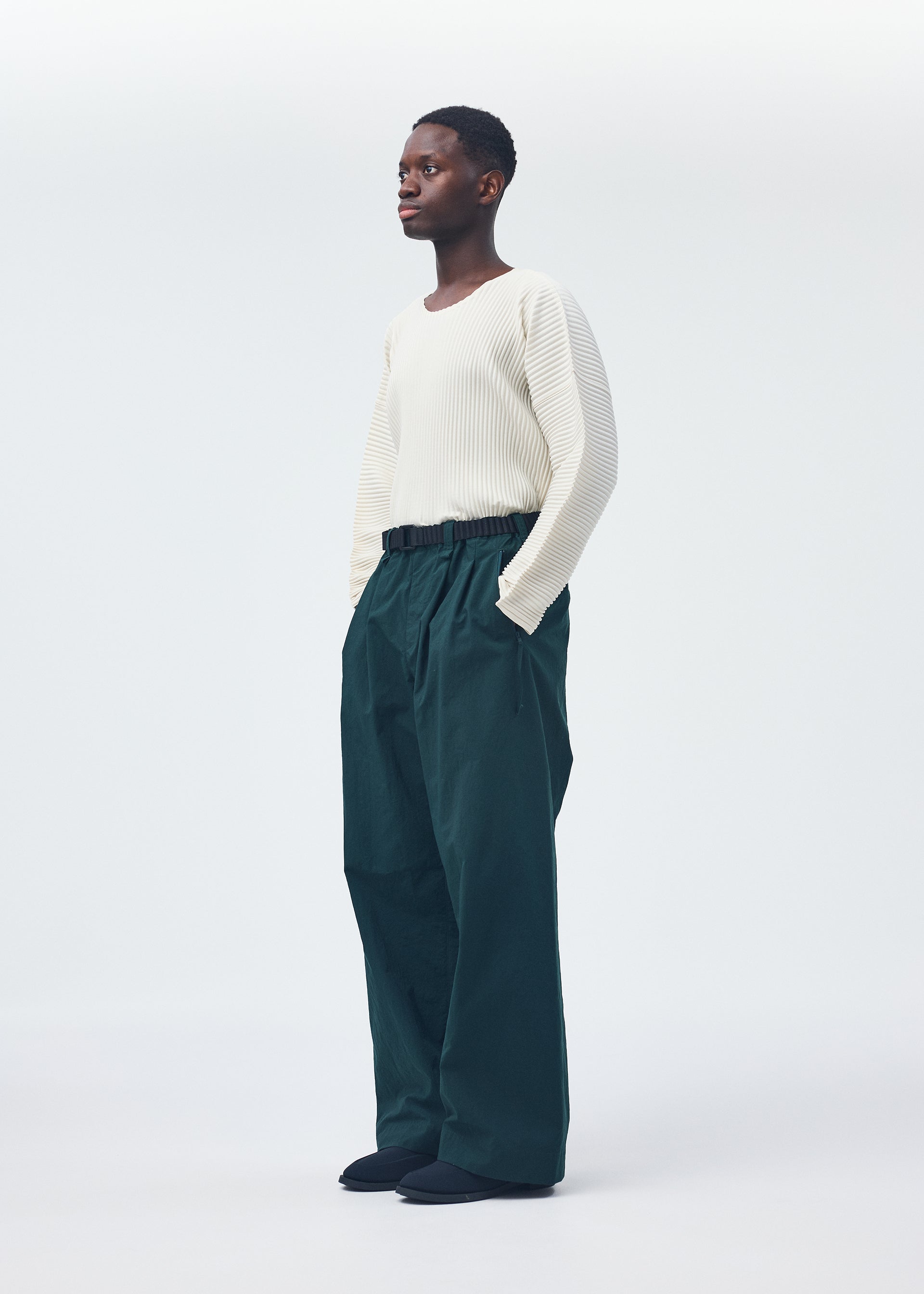 A model wears the Homme Plisse Issey Miyake QUARRY Trousers trousers.