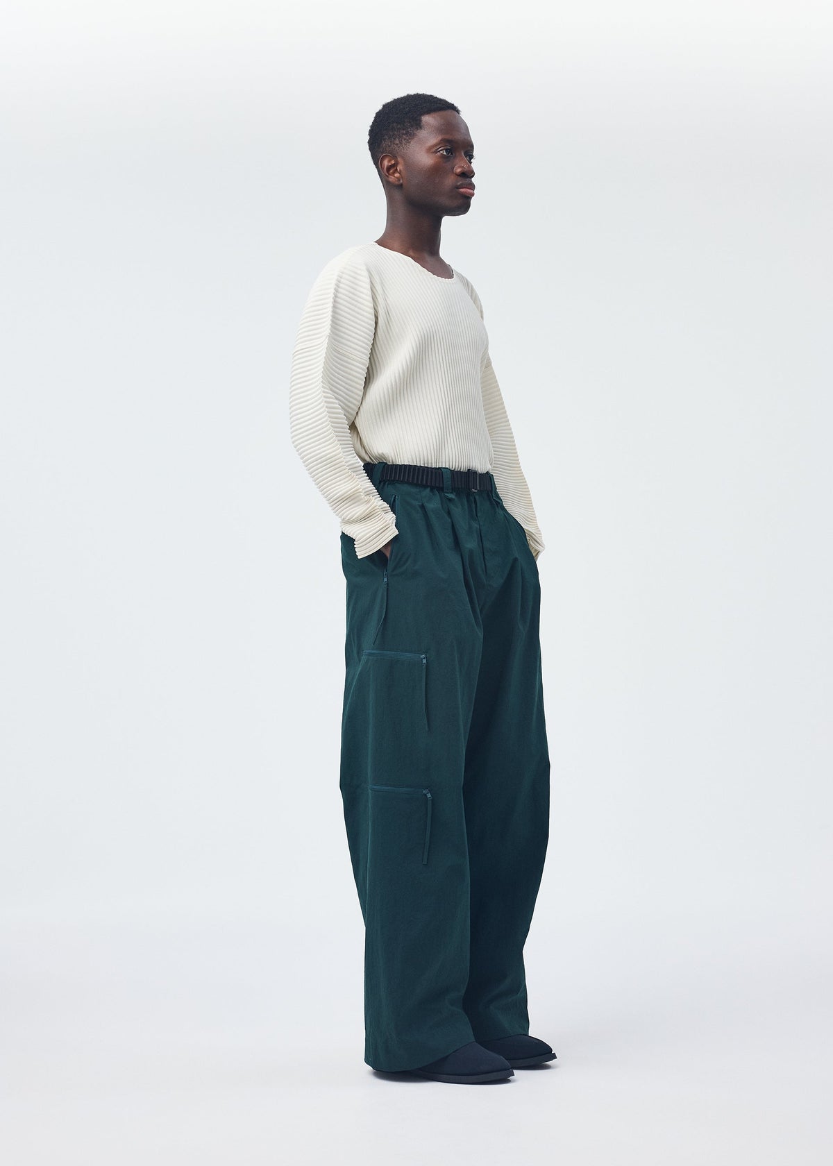 A model wears the Homme Plisse Issey Miyake QUARRY Trousers trousers.