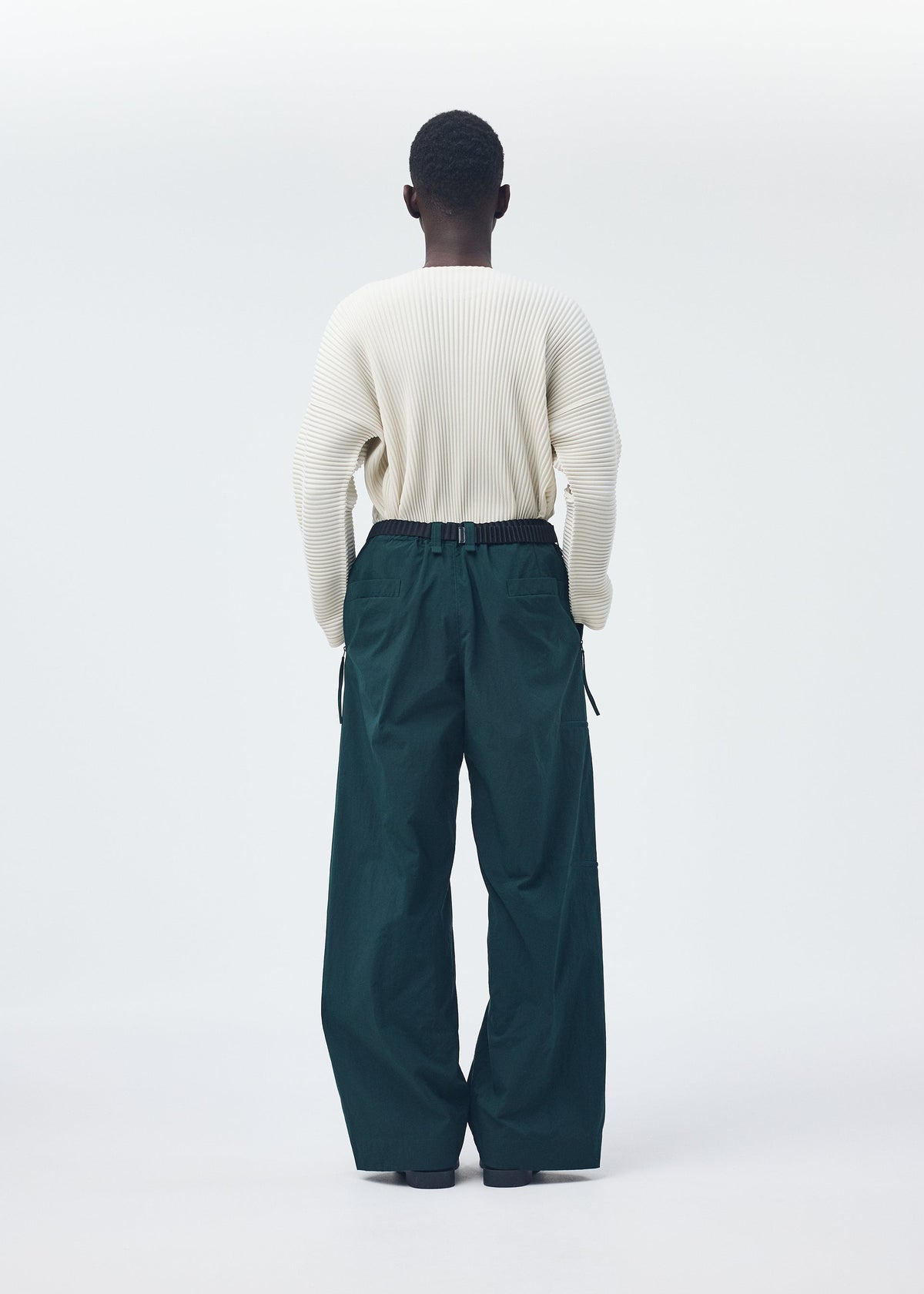 A model wears the Homme Plisse Issey Miyake QUARRY Trousers trousers.