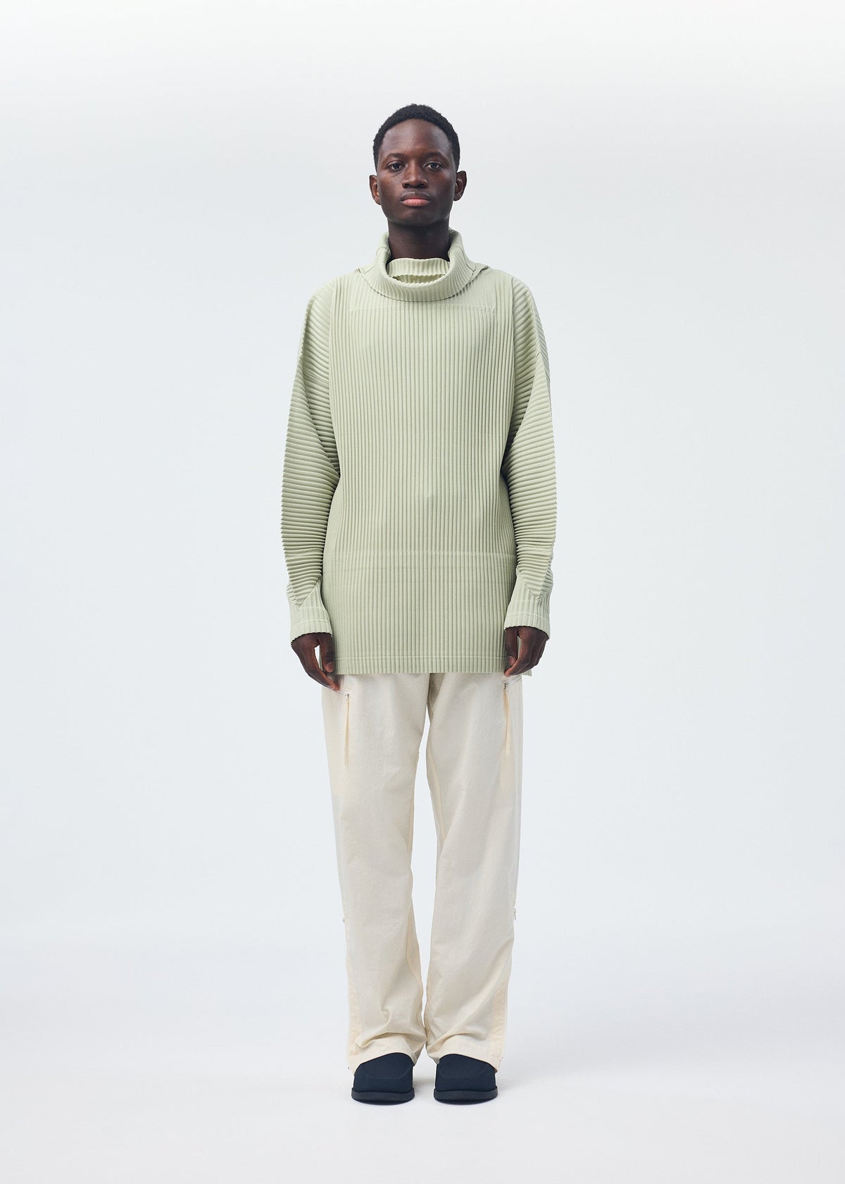 A model wears the Homme Plisse Issey Miyake QUARRY Trousers trousers.