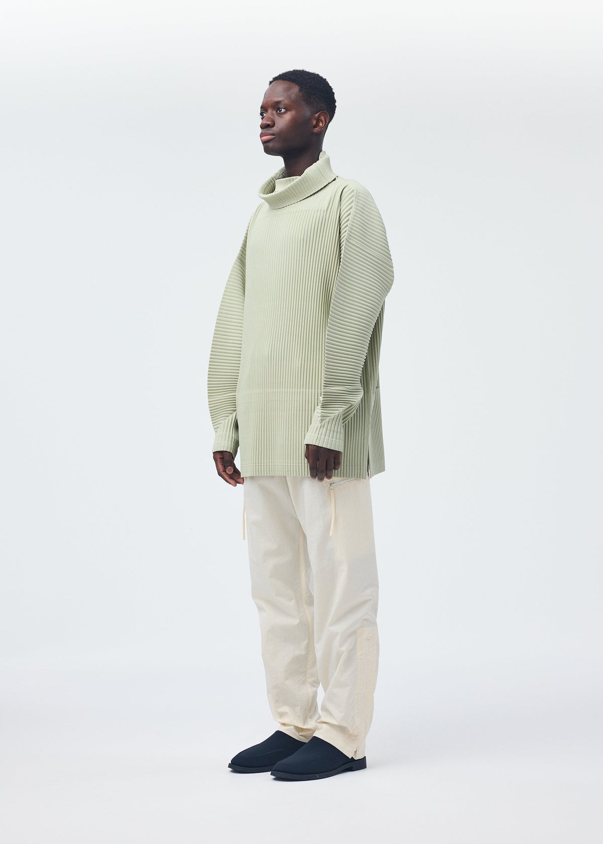 A model wears the Homme Plisse Issey Miyake QUARRY Trousers trousers.