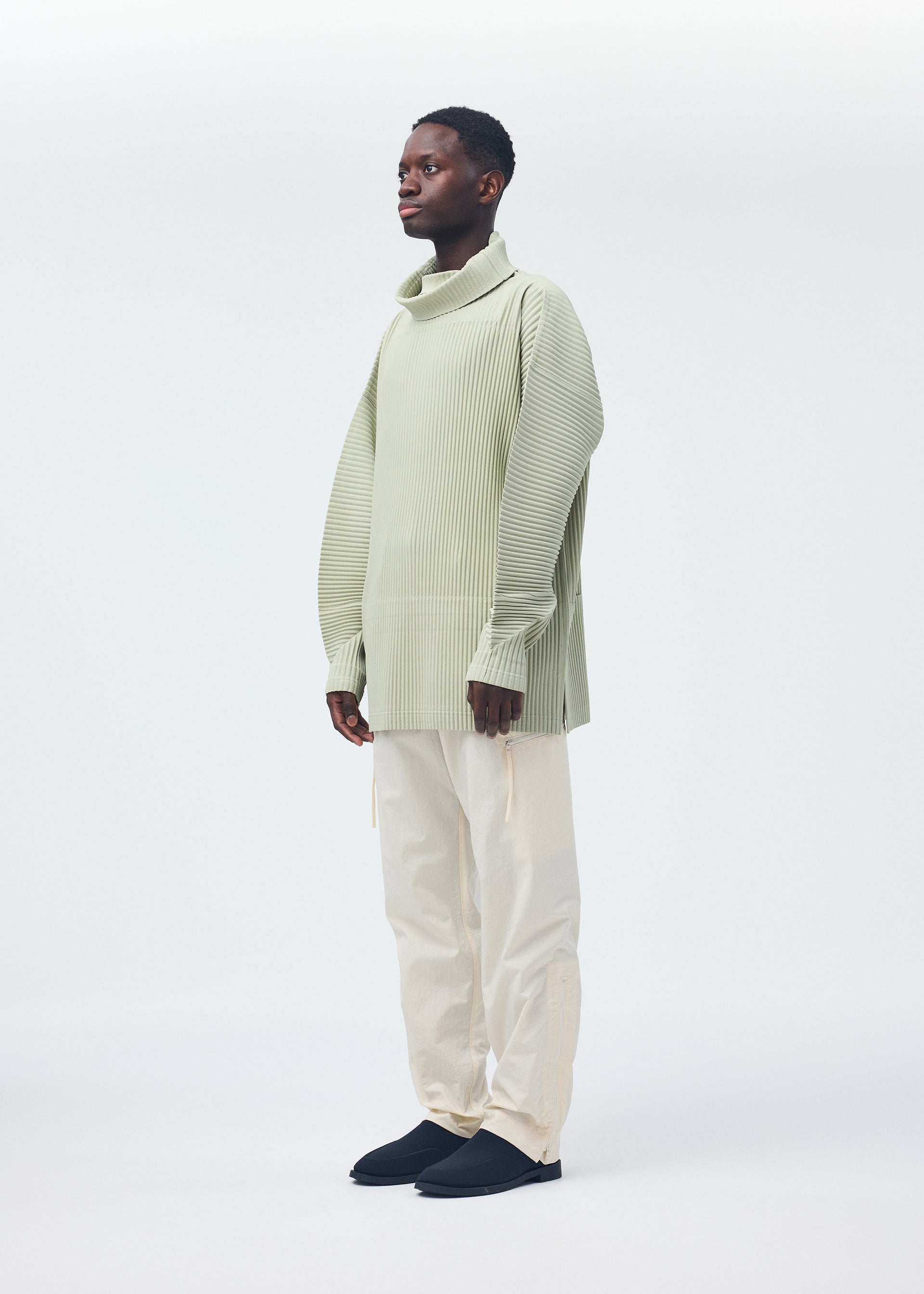A model wears the Homme Plisse Issey Miyake QUARRY Trousers trousers.