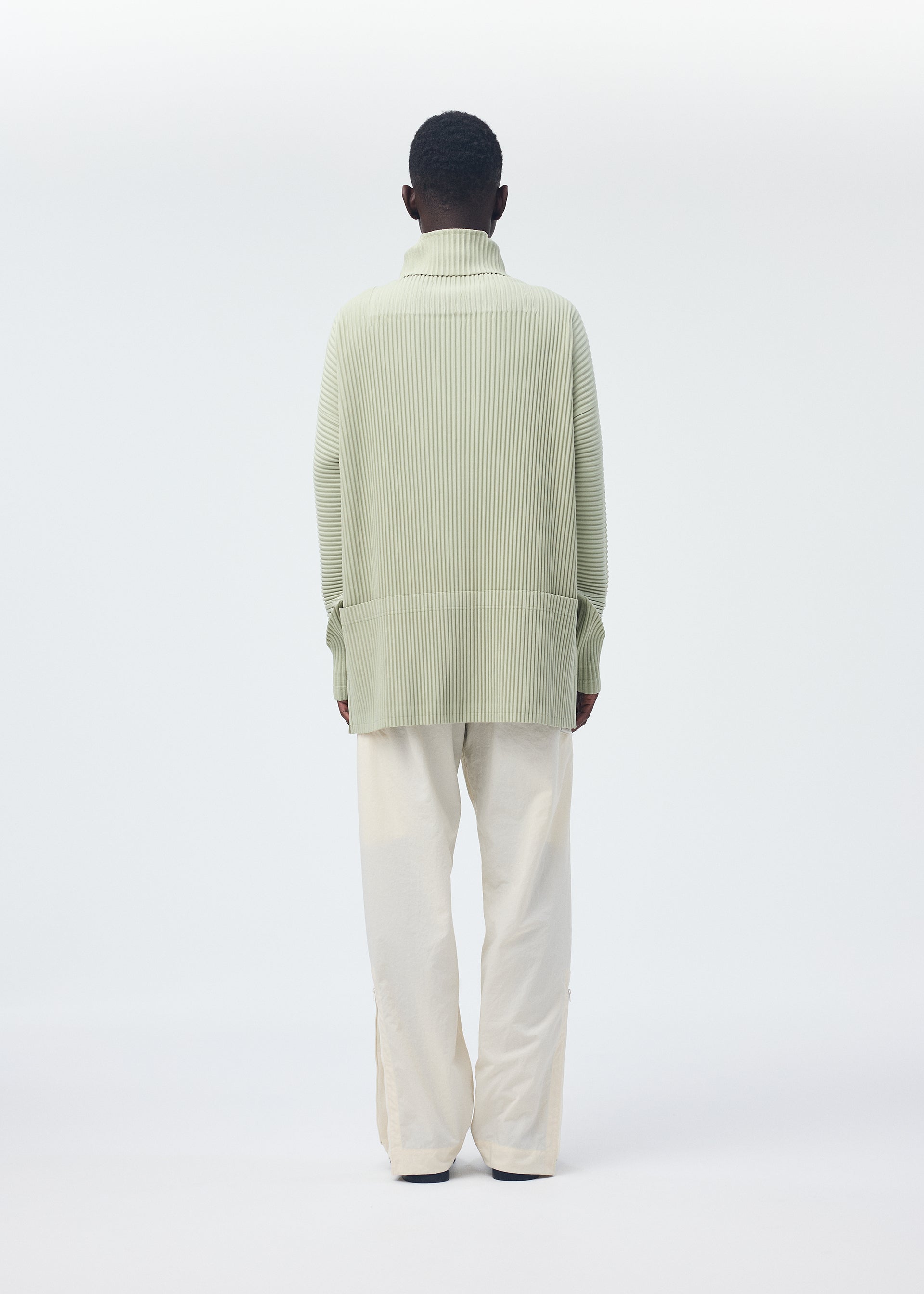 A model wears the Homme Plisse Issey Miyake QUARRY Trousers trousers.
