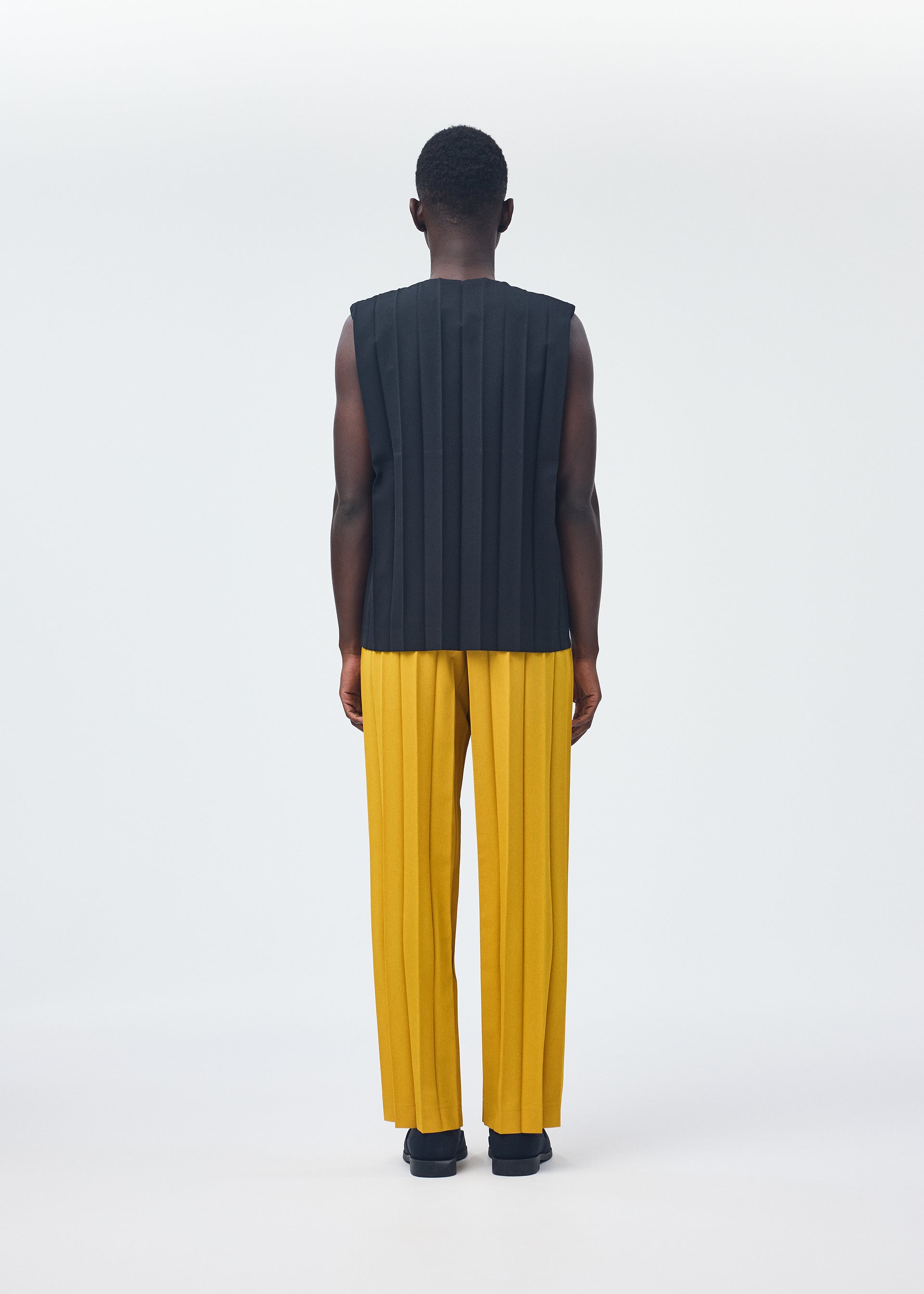 A model wears the Homme Plisse Issey Miyake EDGE ENSEMBLE trousers.