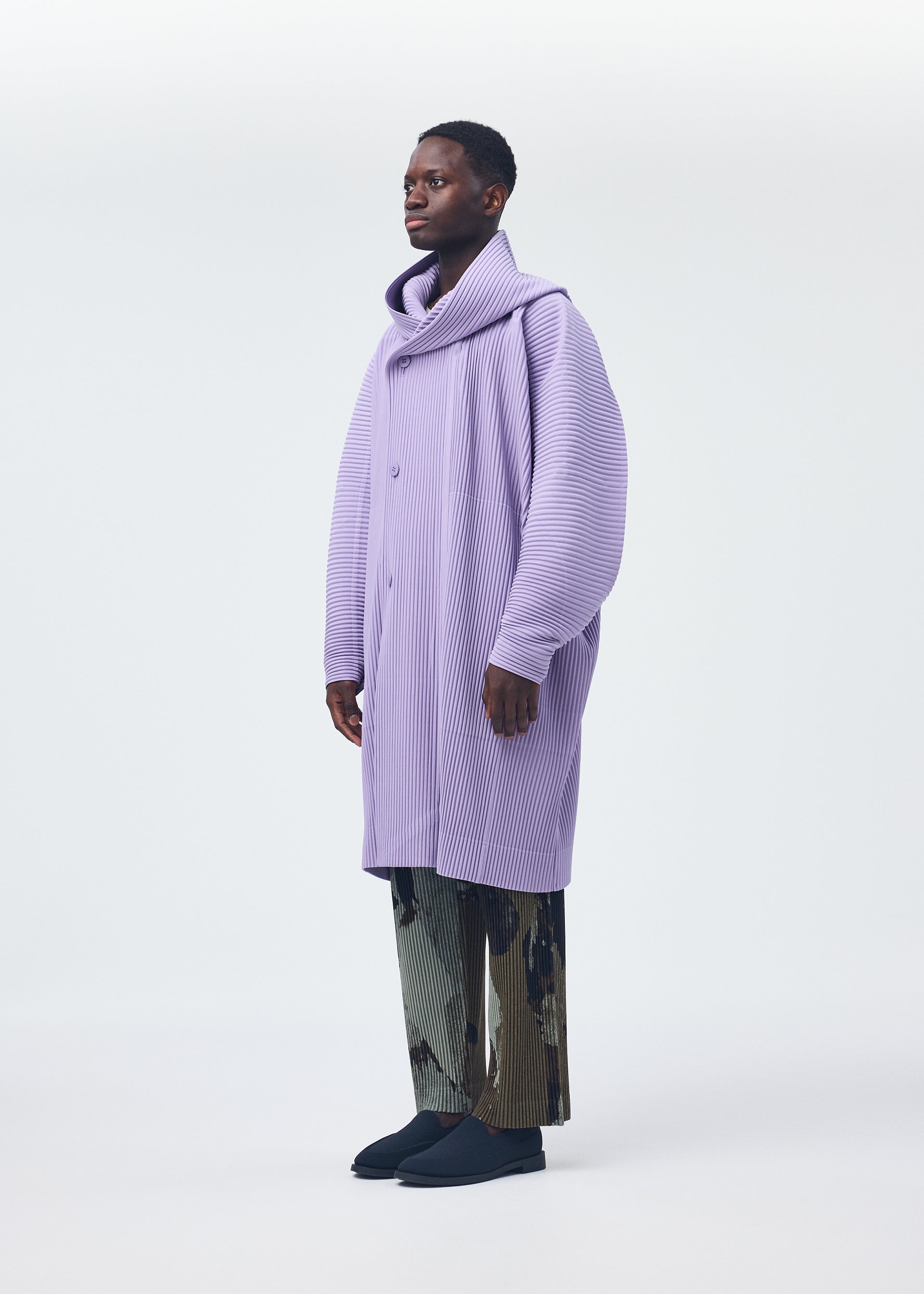 A model wears the Homme Plisse Issey Miyake MONTHLY COLORS : DECEMBER coat.