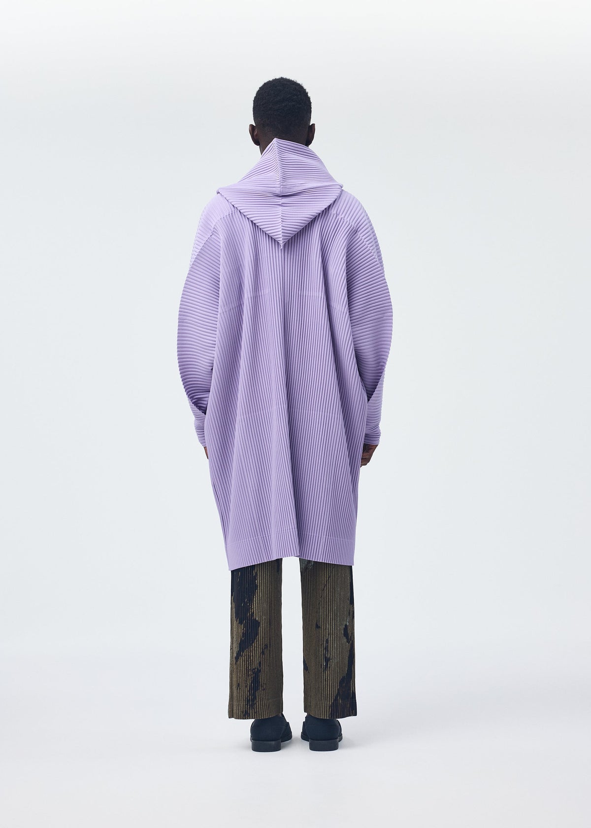 A model wears the Homme Plisse Issey Miyake MONTHLY COLORS : DECEMBER coat.