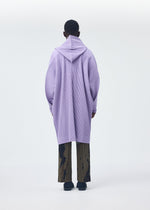 A model wears the Homme Plisse Issey Miyake MONTHLY COLORS : DECEMBER coat.