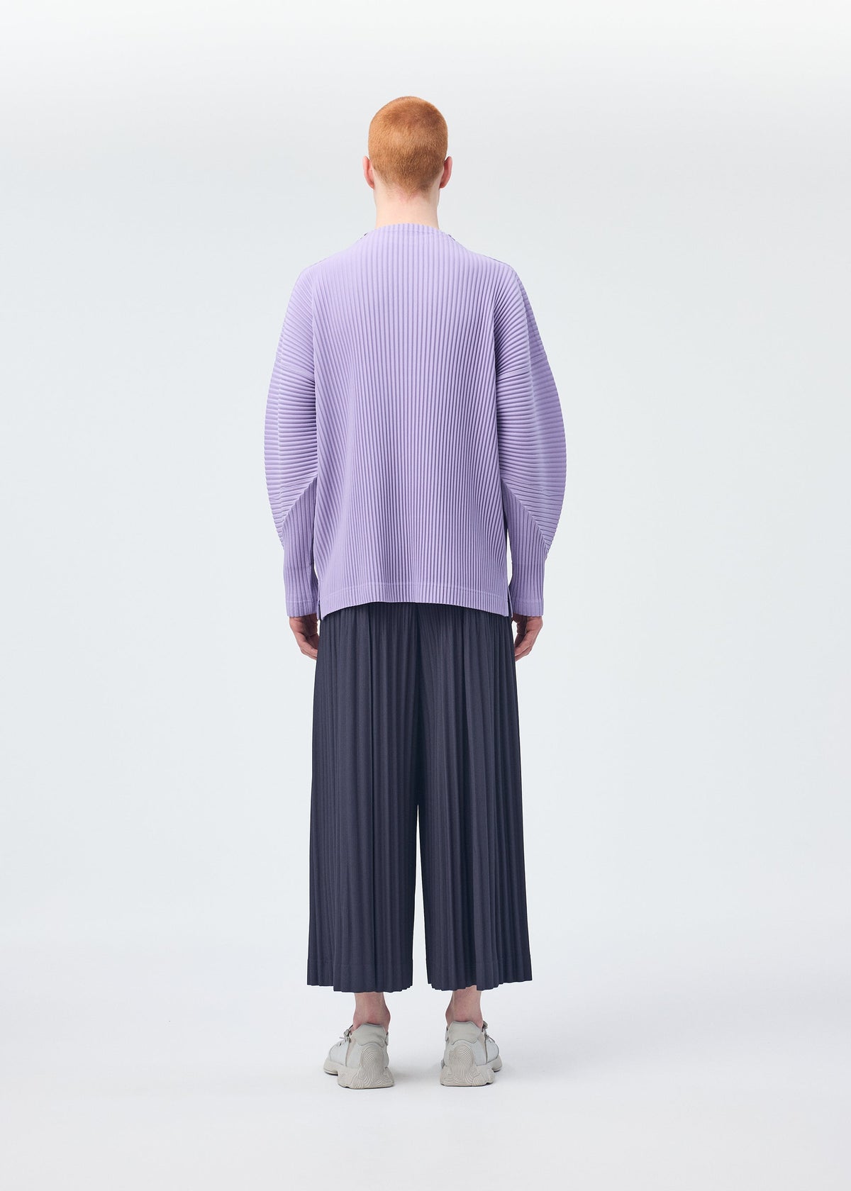 A model wears the Homme Plisse Issey Miyake MONTHLY COLORS : DECEMBER trousers.