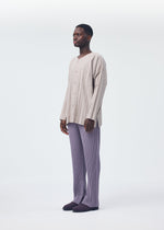 A model wears the HOMME PLISSÉ ISSEY MIYAKE PLEATS BOTTOMS 1 trousers.