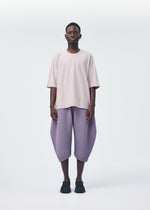 A model wears the HOMME PLISSÉ ISSEY MIYAKE PLEATS BOTTOMS 1 trousers.