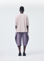 A model wears the HOMME PLISSÉ ISSEY MIYAKE PLEATS BOTTOMS 1 trousers.