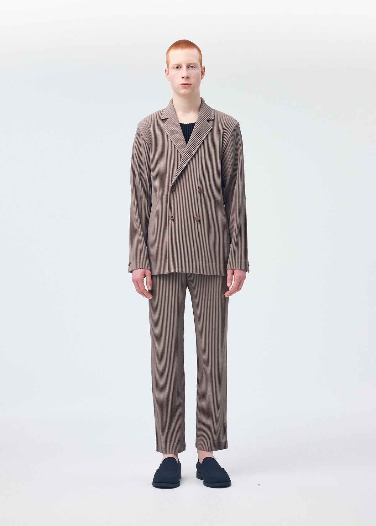 A model wears the Homme Plisse Issey Miyake TAILORED PLEATS 1 trousers.