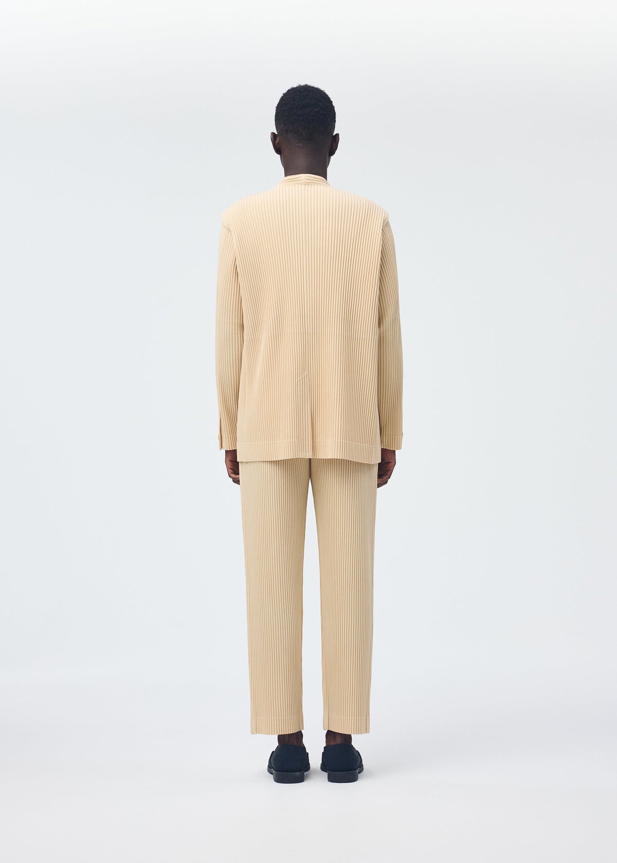 A model wears the Homme Plisse Issey Miyake TAILORED PLEATS 2 trousers.