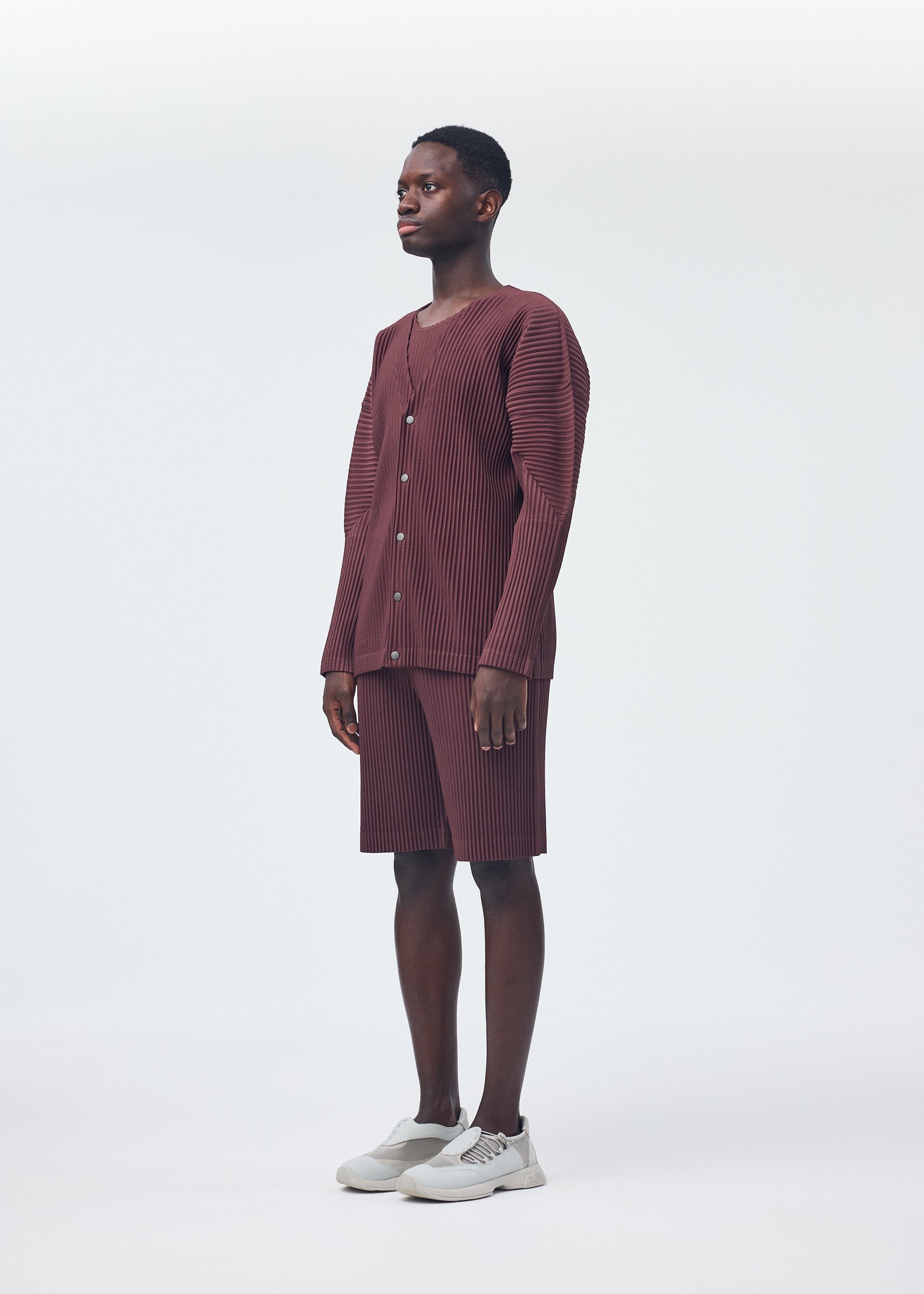 A model wears the HOMME PLISSÉ ISSEY MIYAKE COLOR PLEATS trousers.