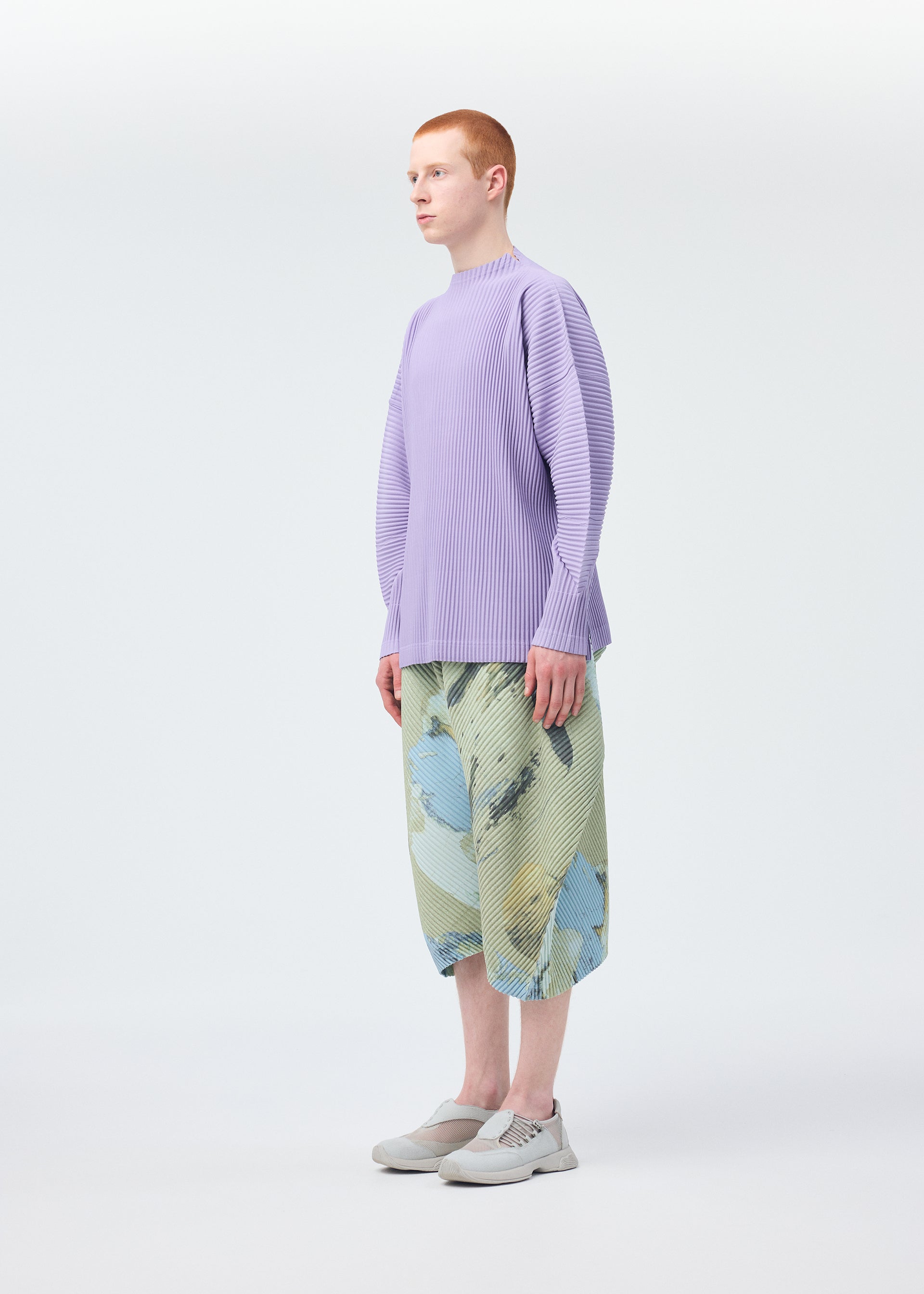 A model wears the Homme Plisse Issey Miyake PAINTED STONE trousers.