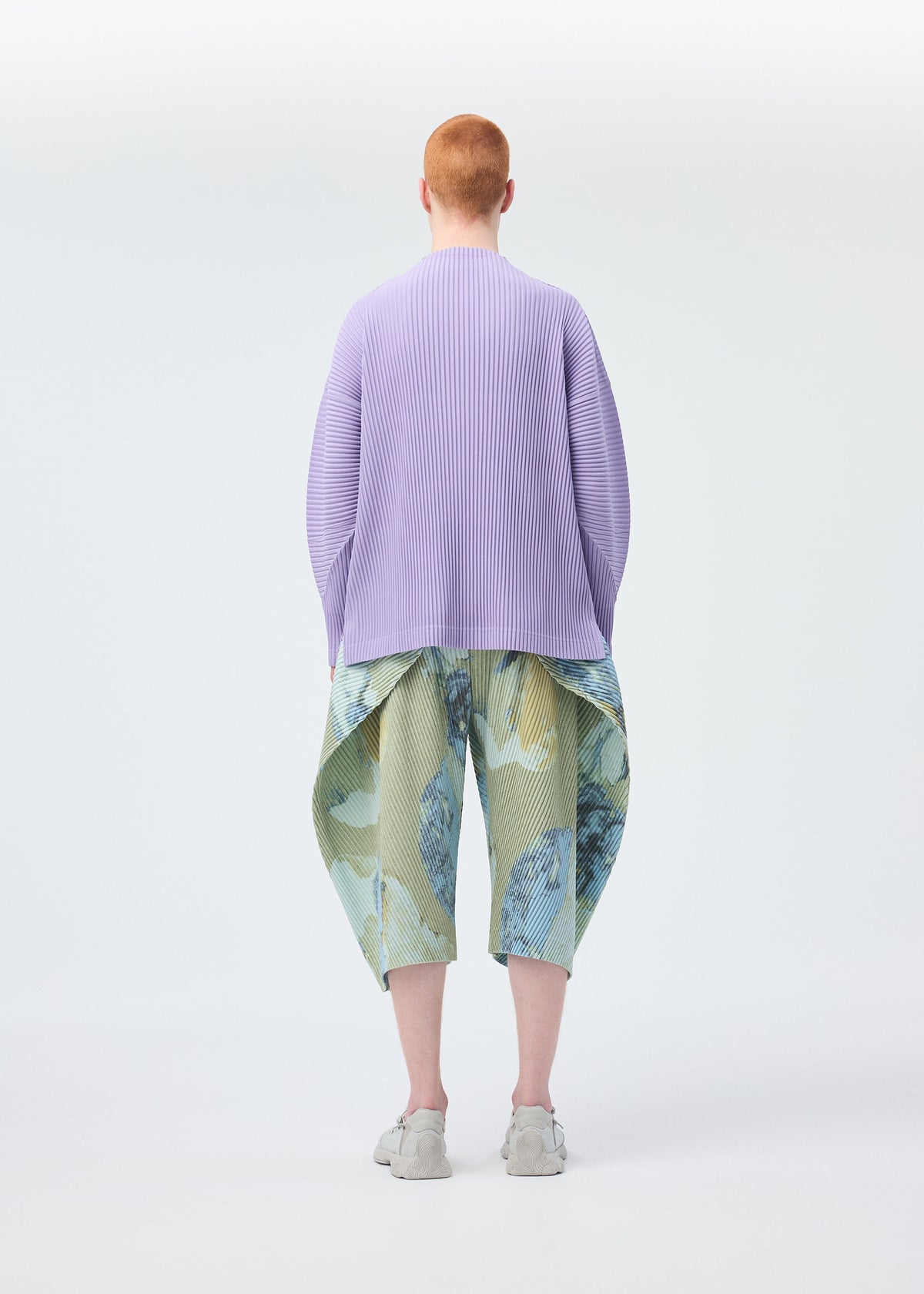 A model wears the Homme Plisse Issey Miyake PAINTED STONE trousers.