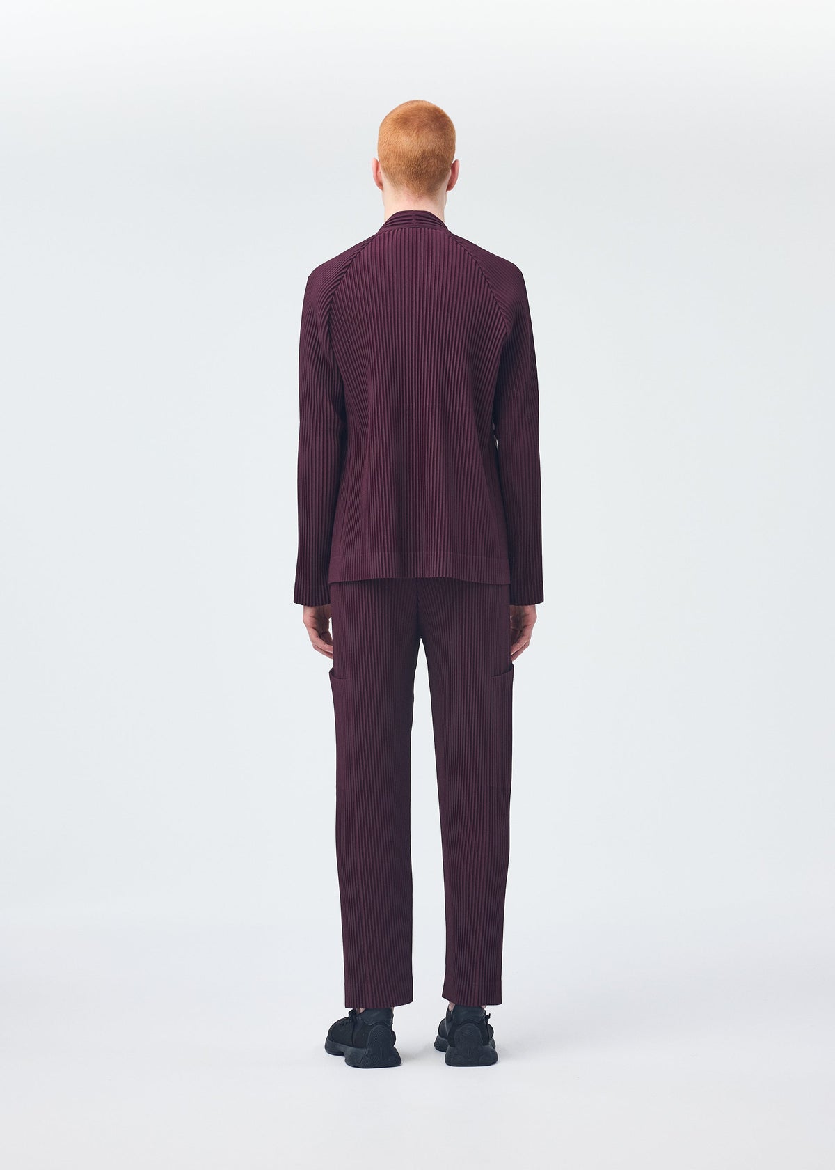 A model wears the Homme Plisse Issey Miyake QUARRY trousers.