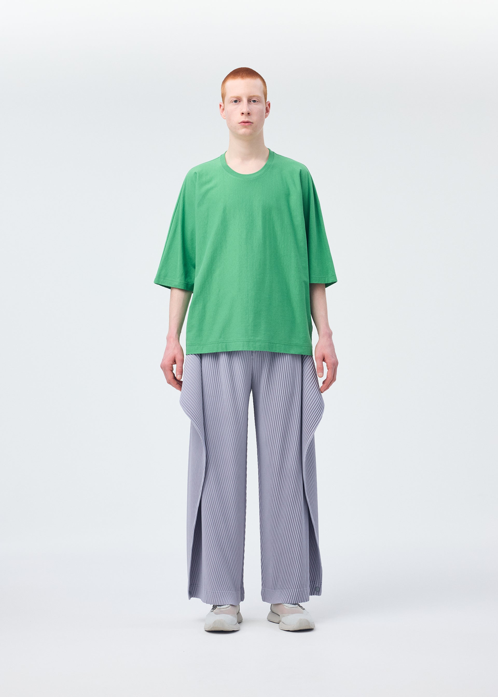 A model wears the Homme Plisse Issey Miyake ANGULAR STONE trousers.