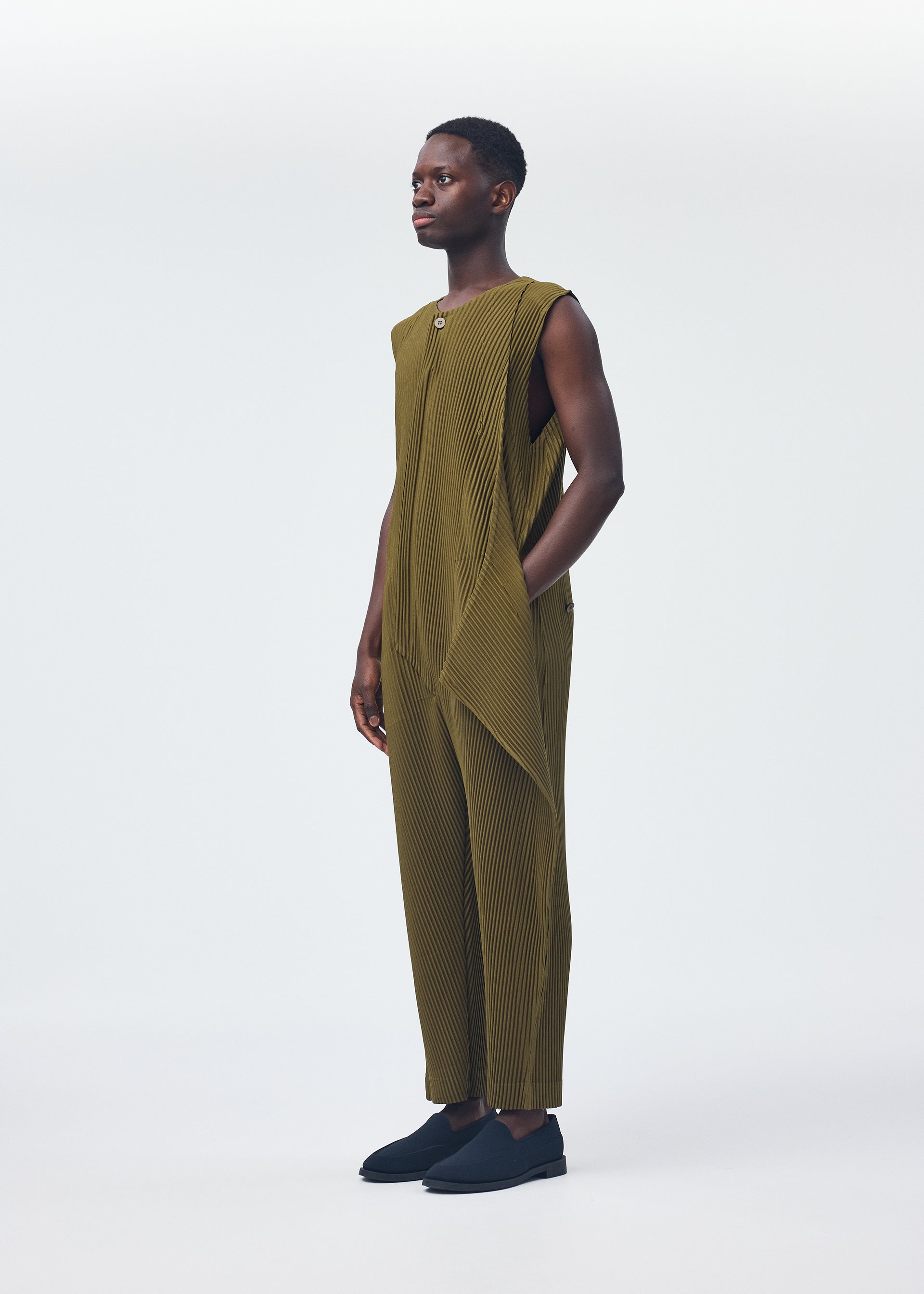 A model wears the Homme Plisse Issey Miyake PLEATS BOTTOMS 2 jumpsuit.