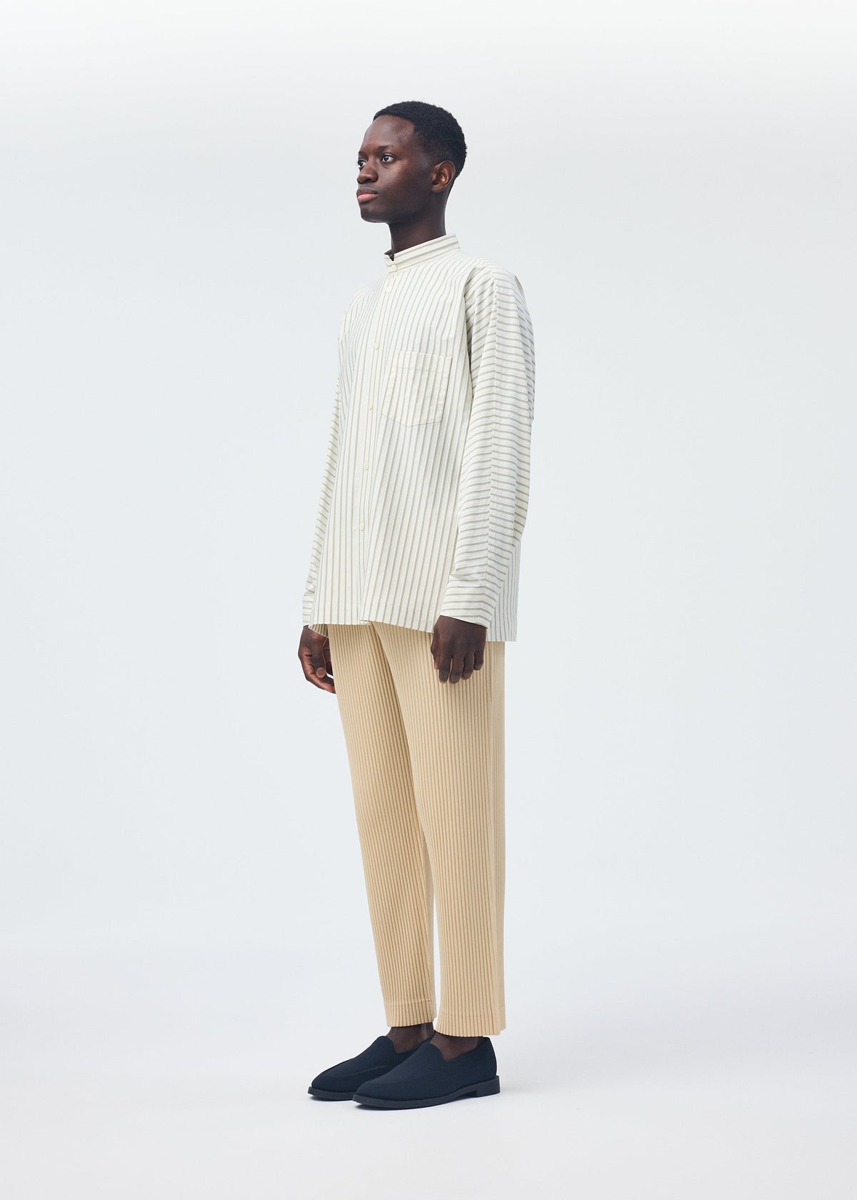 A model wears the Homme Plisse Issey Miyake STRIPE JERSEY SHIRT prêt à porter.