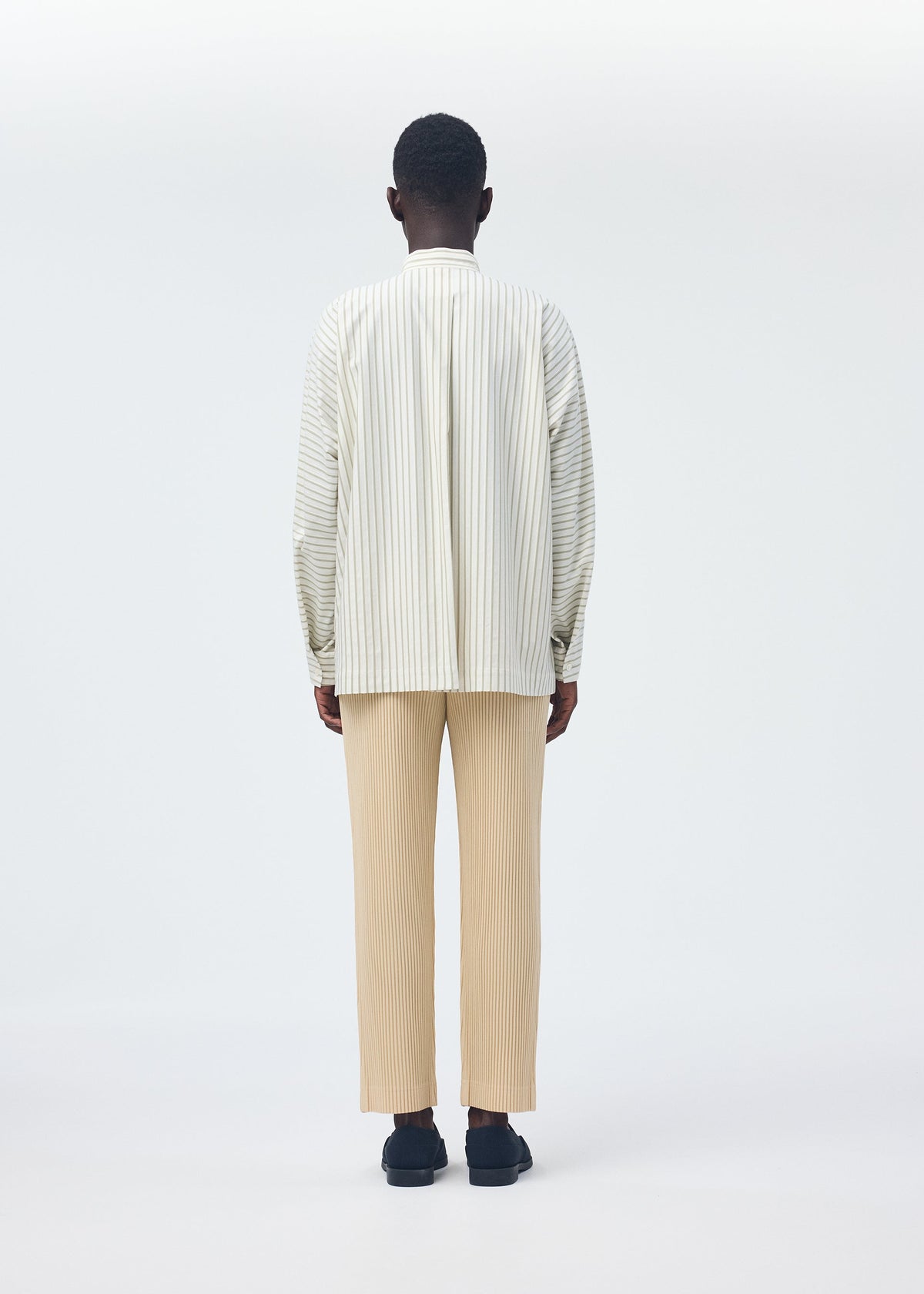A model wears the Homme Plisse Issey Miyake STRIPE JERSEY SHIRT prêt à porter.