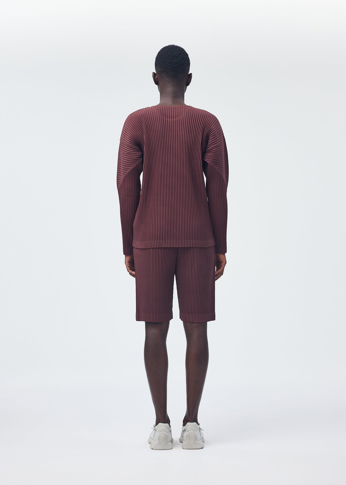 A model wears the HOMME PLISSÉ ISSEY MIYAKE COLOR PLEATS top.