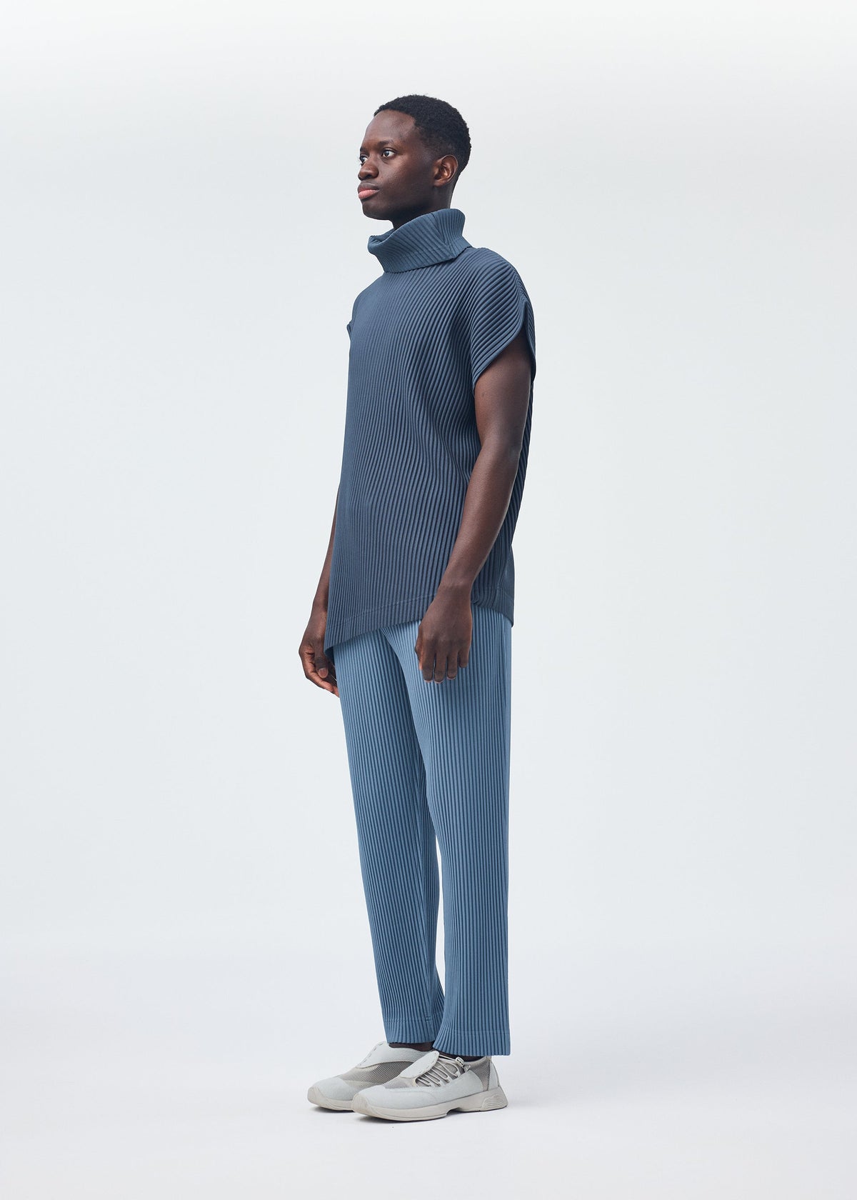 A model wears the Homme Plisse Issey Miyake ANGULAR STONE top.