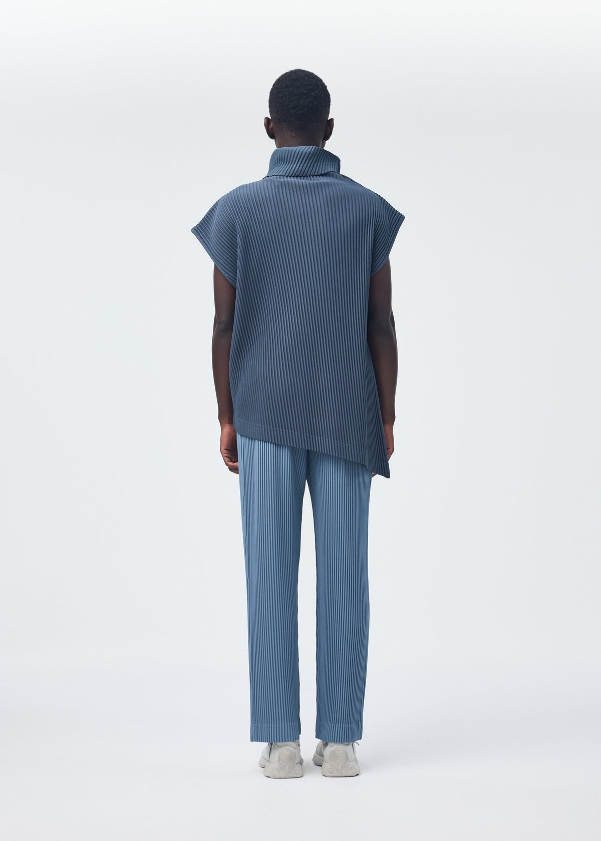 A model wears the Homme Plisse Issey Miyake ANGULAR STONE top.
