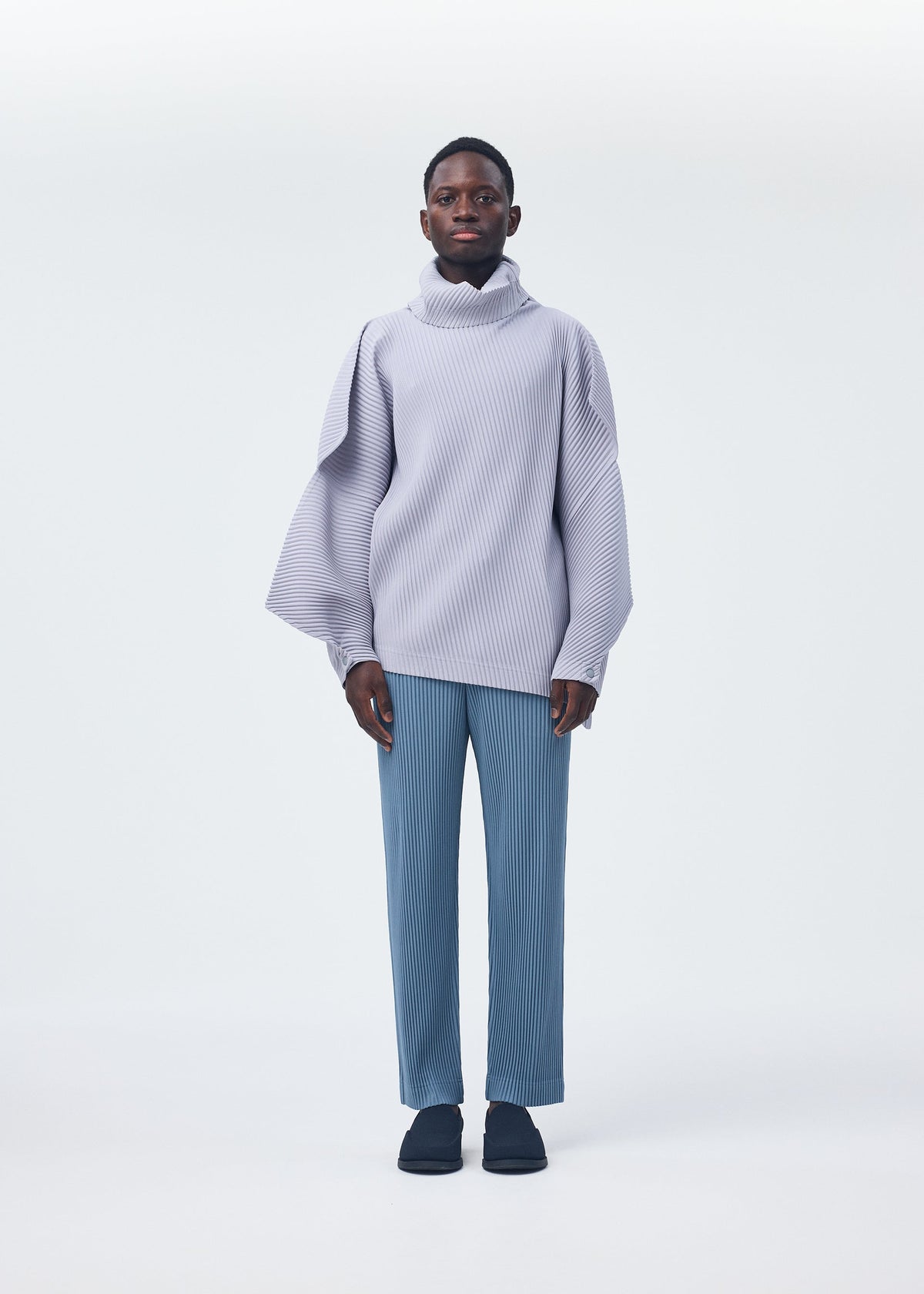 A model wears the Homme Plisse Issey Miyake ANGULAR STONE top.
