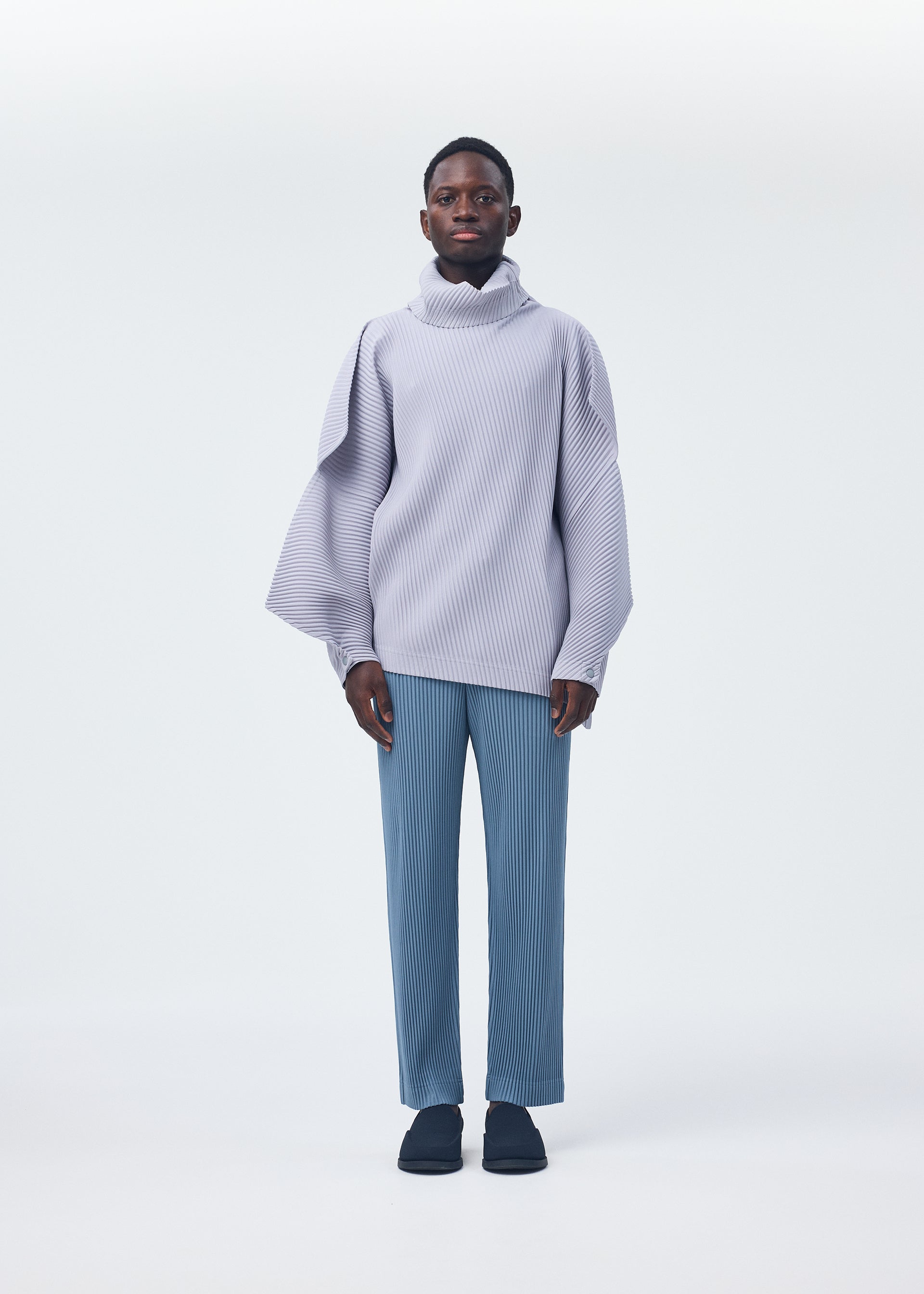 A model wears the Homme Plisse Issey Miyake ANGULAR STONE top.