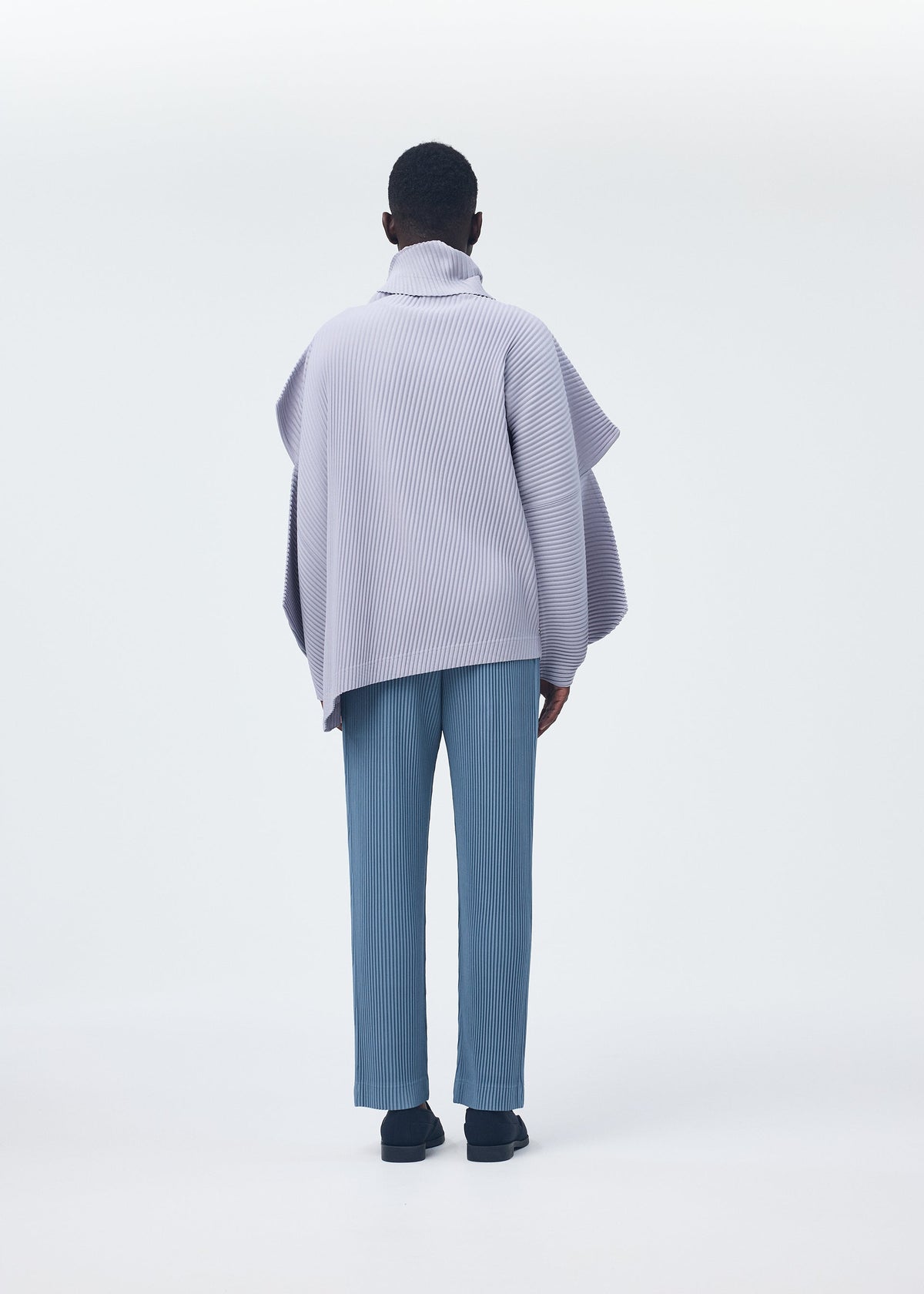 A model wears the Homme Plisse Issey Miyake ANGULAR STONE top.