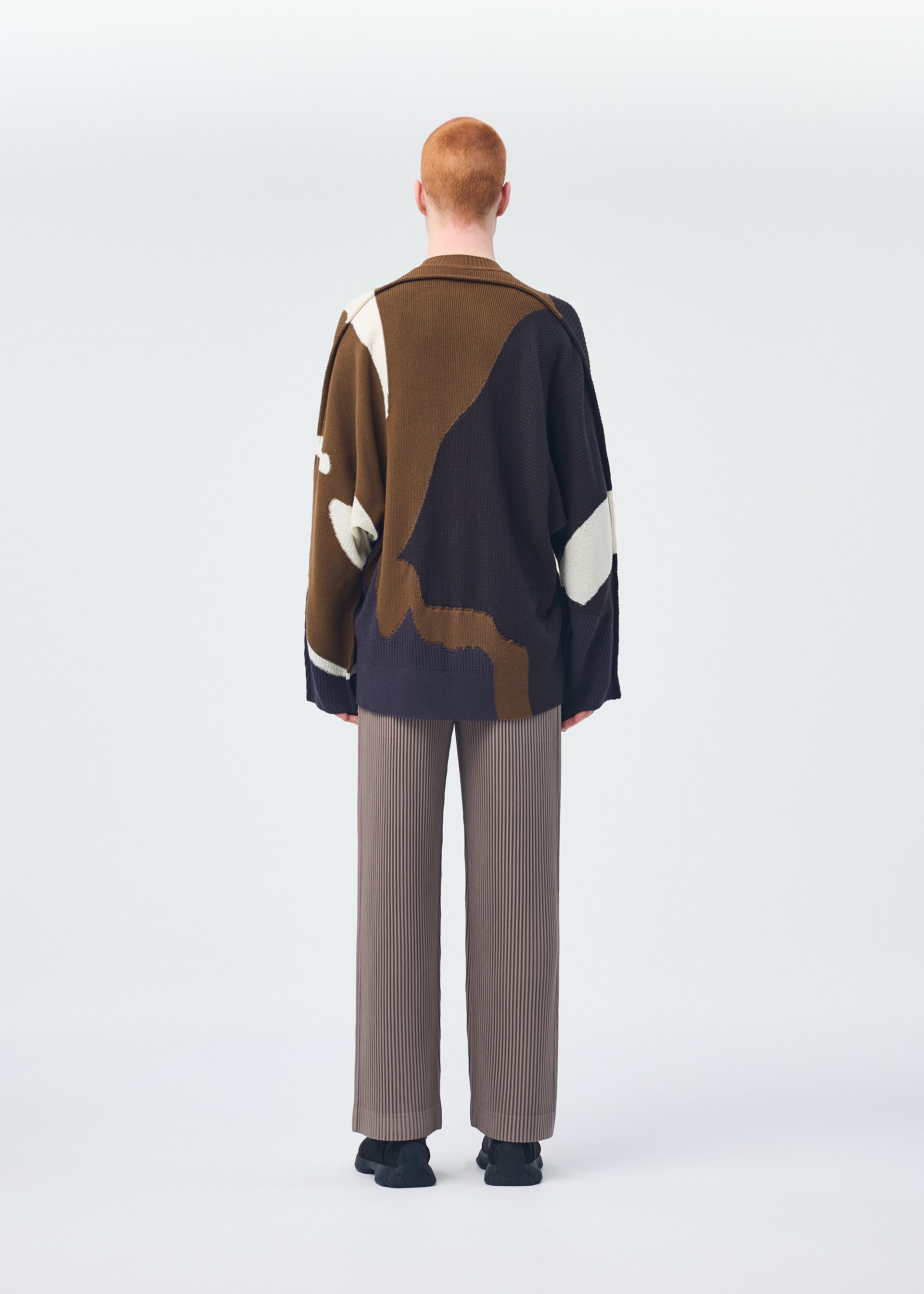 A model wears the Homme Plisse Issey Miyake AGATE KNIT top.