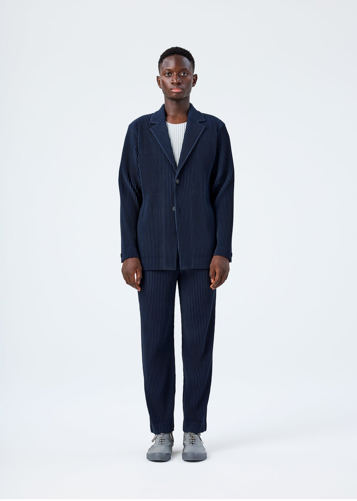 A model wears the HOMME PLISSÉ ISSEY MIYAKE BASICS basics-jacket-black-1-fw26.