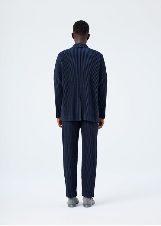A model wears the HOMME PLISSÉ ISSEY MIYAKE BASICS basics-jacket-navy-2-fw26.