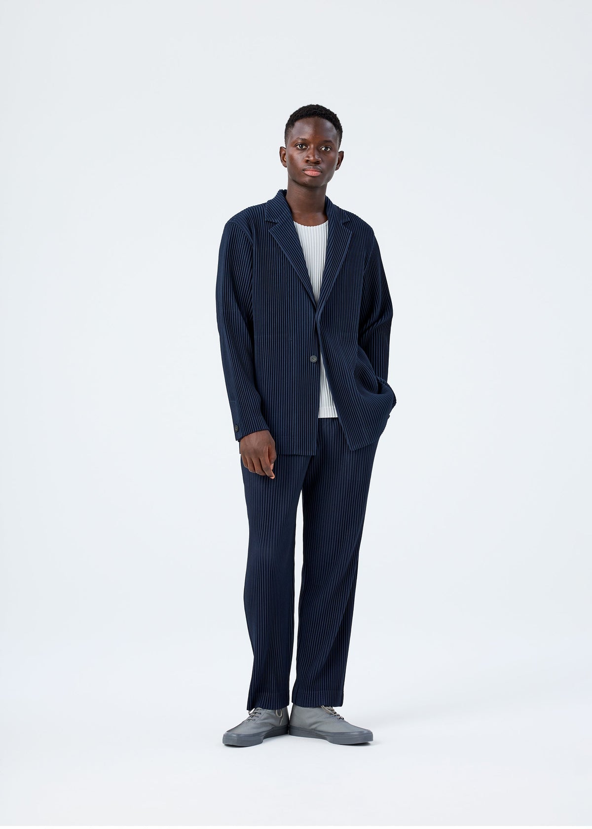 A model wears the HOMME PLISSÉ ISSEY MIYAKE BASICS basics-jacket-black-1-fw26.