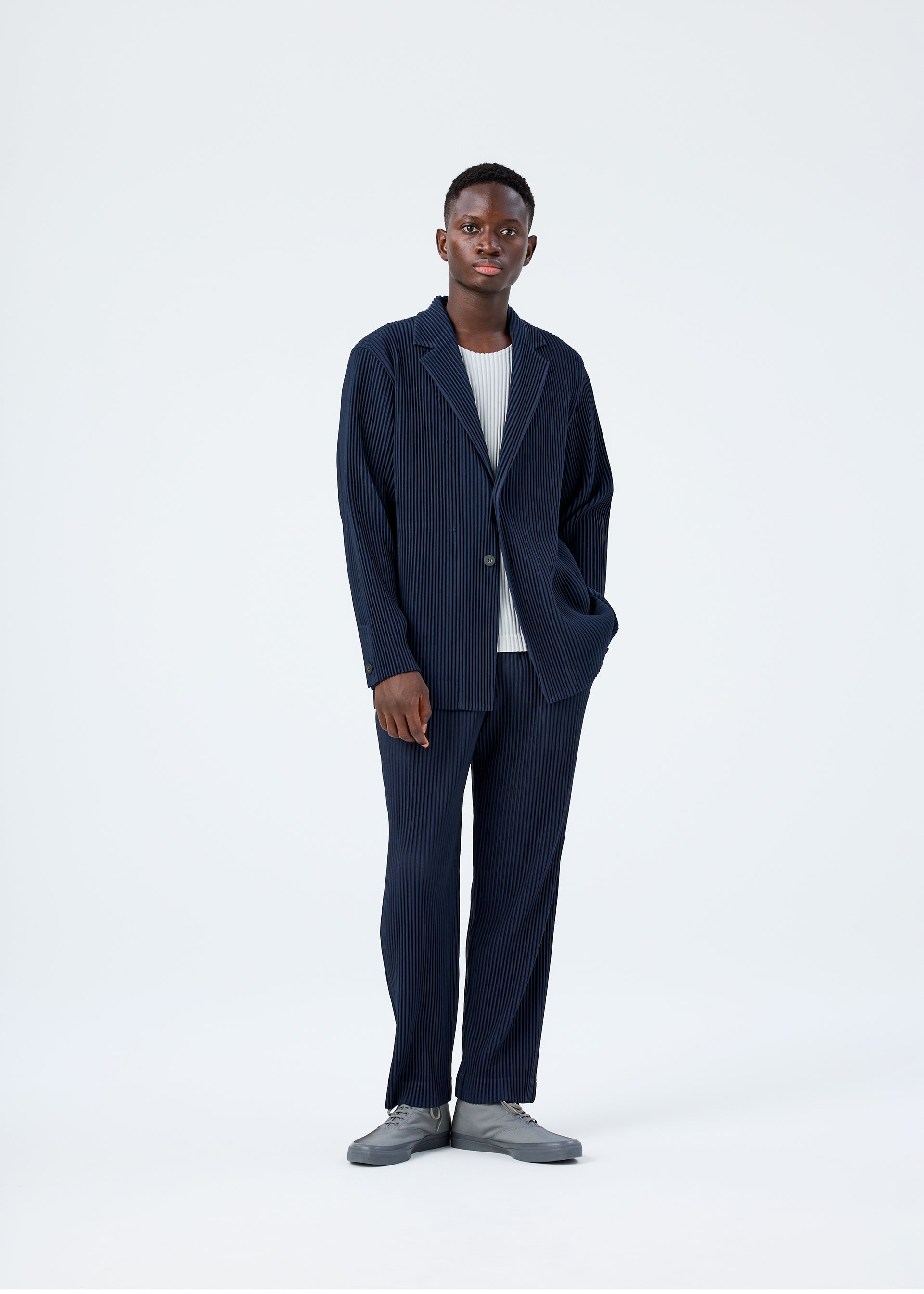 A model wears the HOMME PLISSÉ ISSEY MIYAKE BASICS basics-jacket-black-1-fw26.