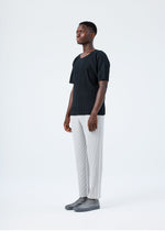 A model wears the HOMME PLISSÉ ISSEY MIYAKE BASICS basics-trousers-navy-2-fw26.