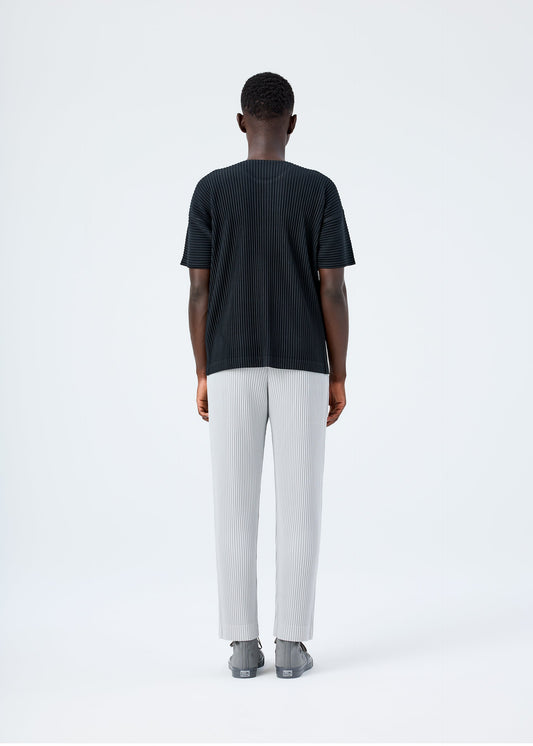 A model wears the HOMME PLISSÉ ISSEY MIYAKE BASICS basics-trousers-black-1-fw26.