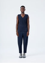 A model wears the HOMME PLISSÉ ISSEY MIYAKE BASICS basics-trousers-navy-5-fw26.