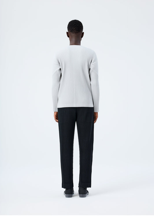 A model wears the HOMME PLISSÉ ISSEY MIYAKE BASICS basics-shirt-black-fw26.