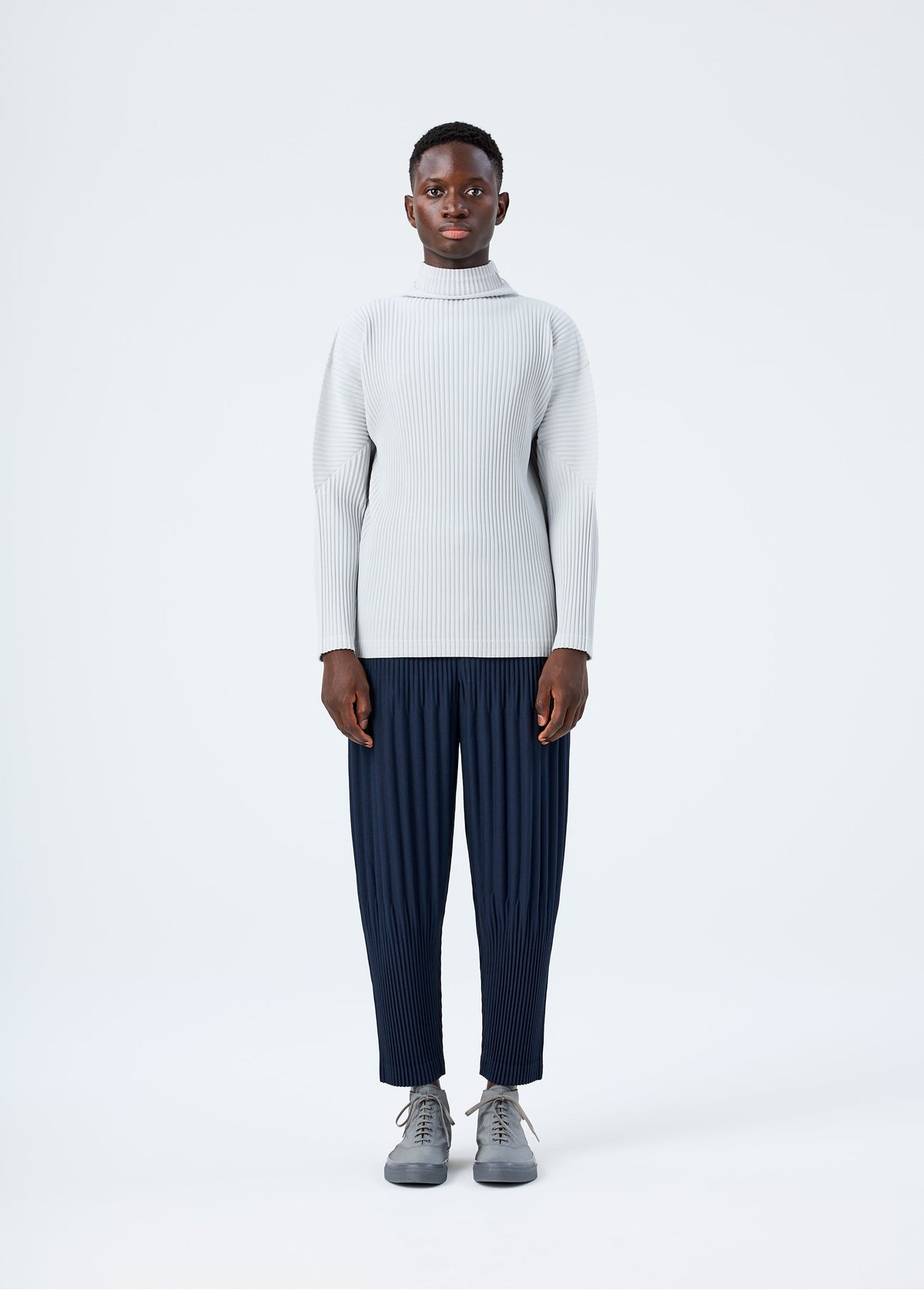 A model wears the HOMME PLISSÉ ISSEY MIYAKE BASICS basics-shirt-black-2-fw26.